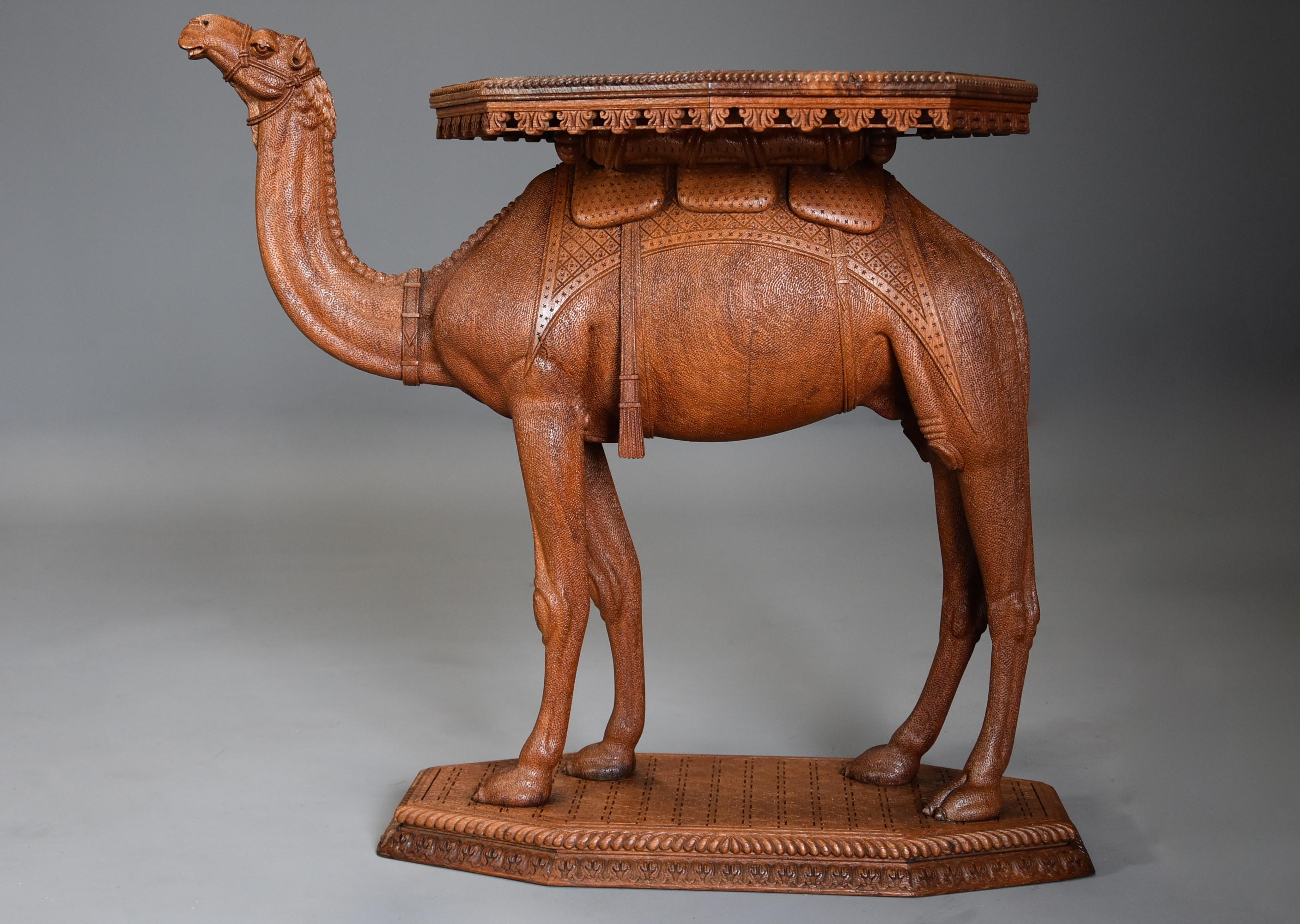 A late 19th century Anglo Indian hardwood camel table of superb quality and good patina, possibly from the Gujarat region of India. 

This table consists of an octagonal top, the central section surrounded by profusely carved foliate decoration