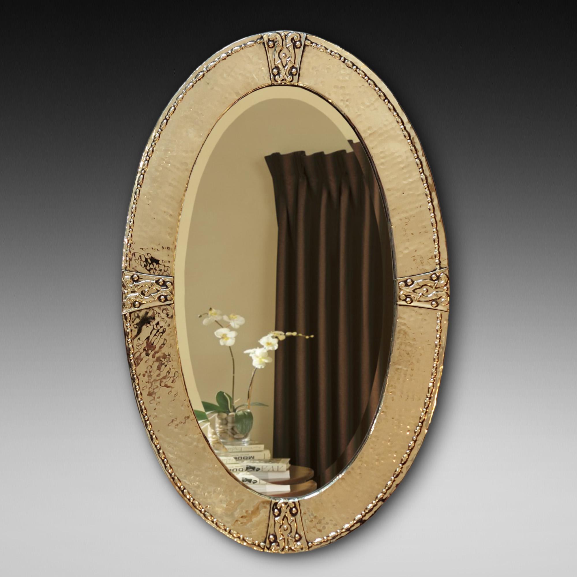 Miroir en laiton battu Arts and Crafts de la fin du 19ème siècle de forme ovale avec rosettes en laiton appliquées et miroir à plaque biseautée d'origine - 18,5 