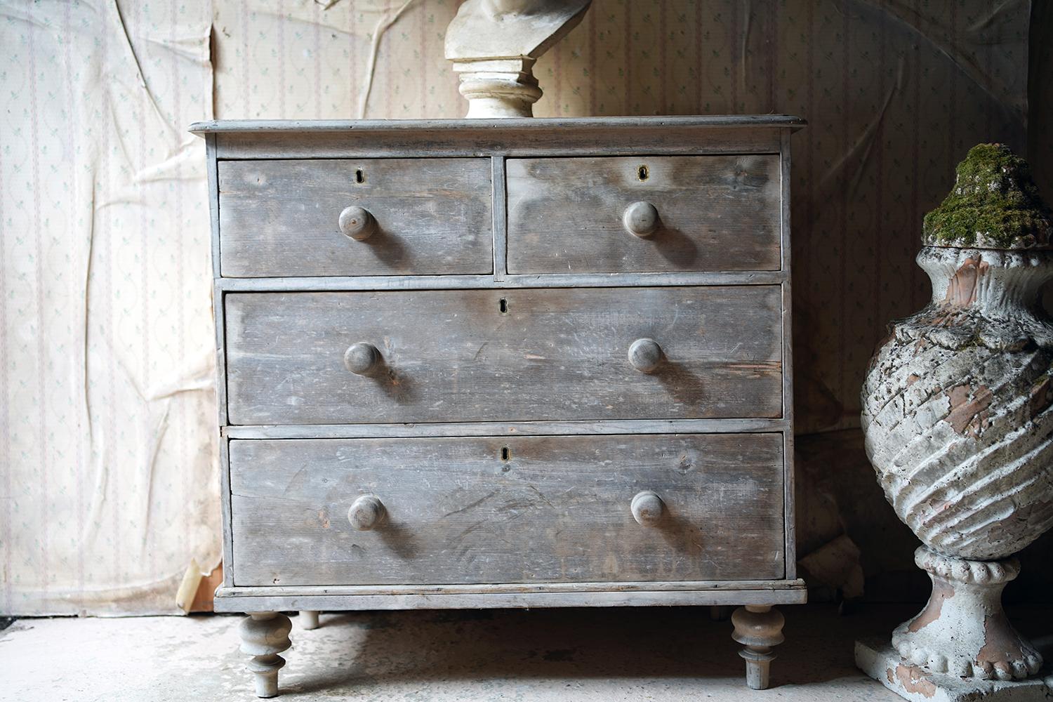 Of desirable diminutive proportions and a wonderfully naturally bleached elephant grey patina, the Victorian pine chest of drawers having a rectangular top above two short and two long drawers, each with original knob handles, and raised on stylized