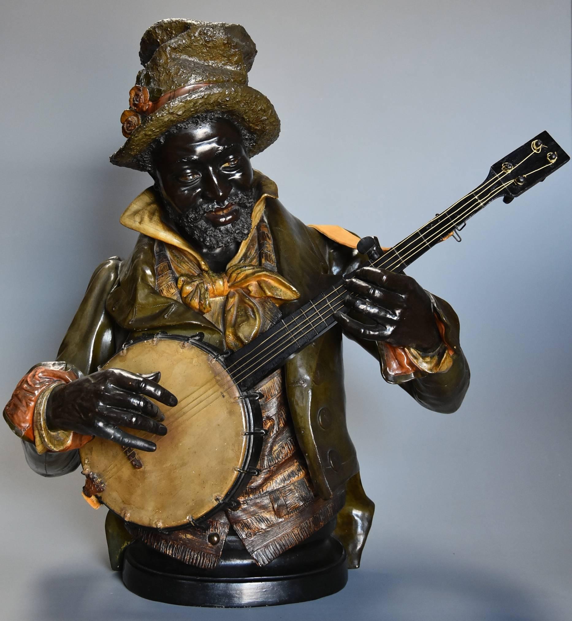 A highly decorative late 19th century fine quality lifesize polychrome terracotta bust of the 'Banjo Player' After Pietro Calvi (1833-1884).

This polychrome terracotta figure depicts a Minstrel happily playing his banjo dressed in a hat, jacket