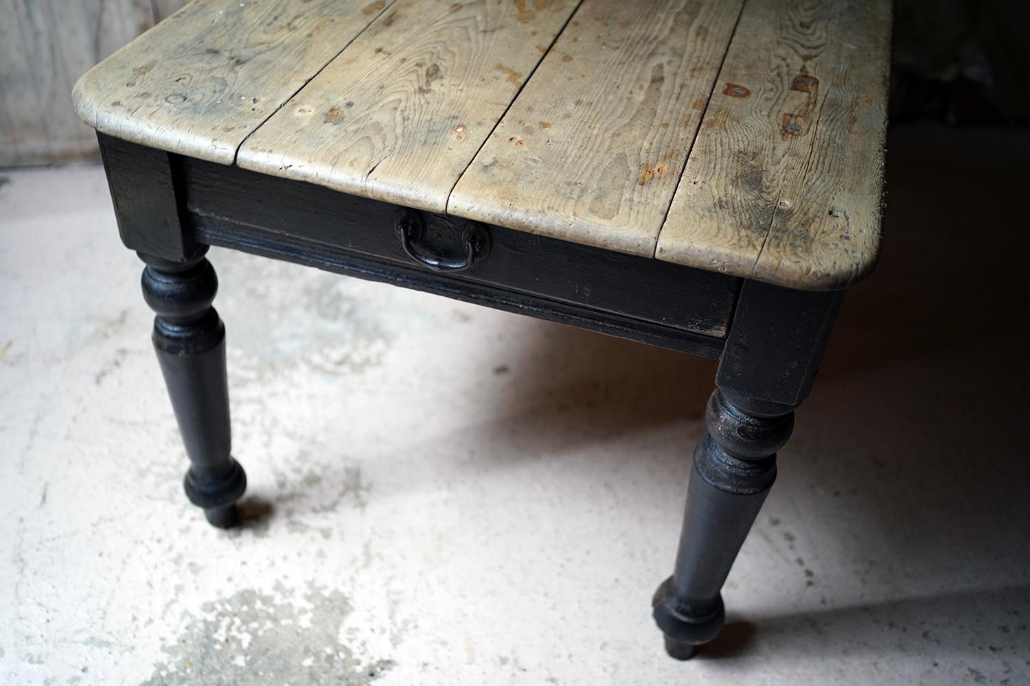 Sourced from North Wales, the bold and attractive farmhouse estate made table, having a four plank scrub pine top with rounded edges over a black painted base to imposing well-turned baluster legs and rule lined frieze to a single deep drawer with