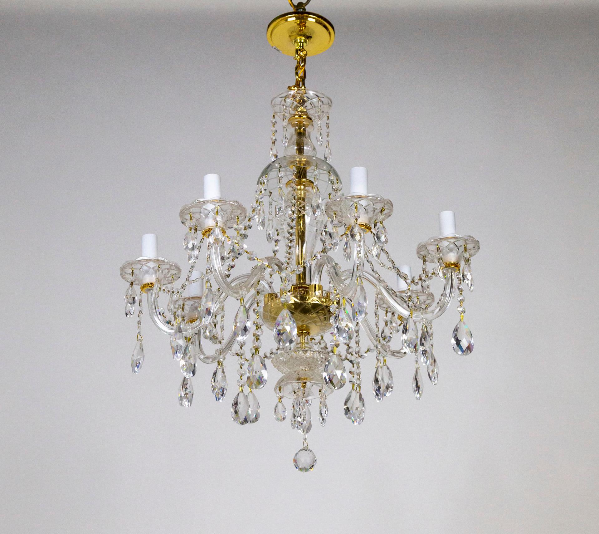 A 7-light chandelier made of Bohemian molded glass and dangling, sharply-cut, almond crystals. With crystal-beaded garlands and a gold-toned stem and accents. circa 1970s. Measures: 33.5
