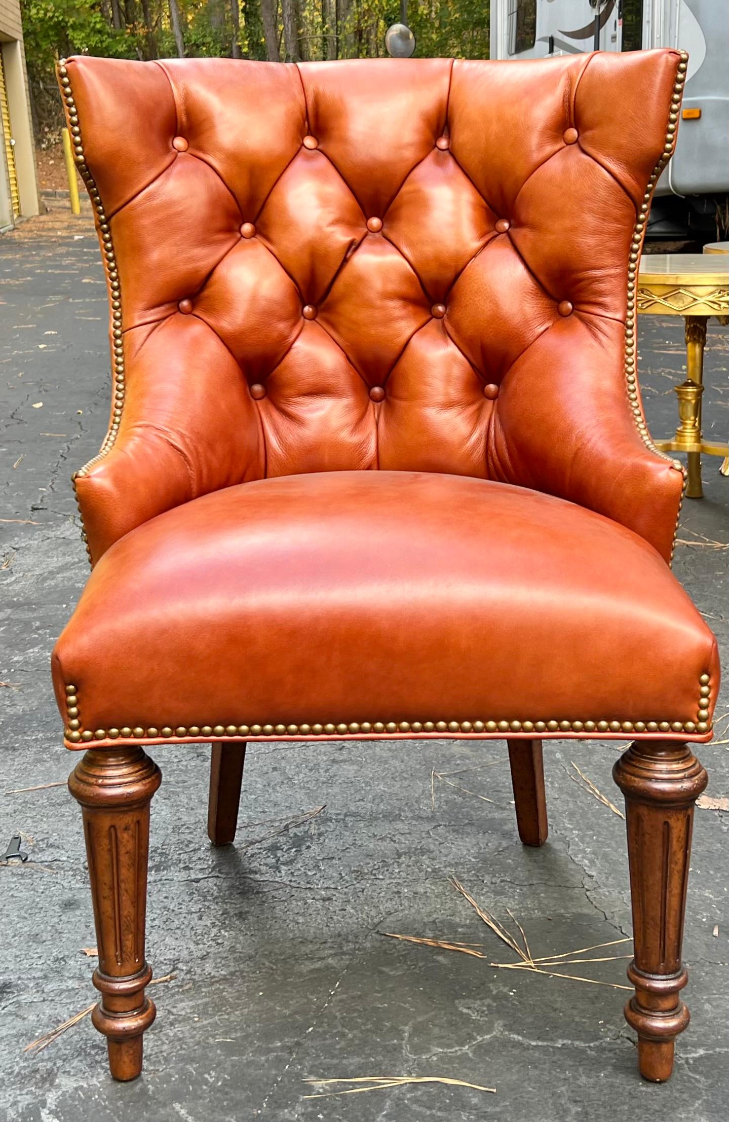 These chairs are have timeless appeal. This is a pair of saddle leather Chesterfield style chairs. They are attributed to Hancock and Moore but are unmarked. The leather is in very good condition. The tapered legs are fruitwood. Arm ; 22.5”. Seat;