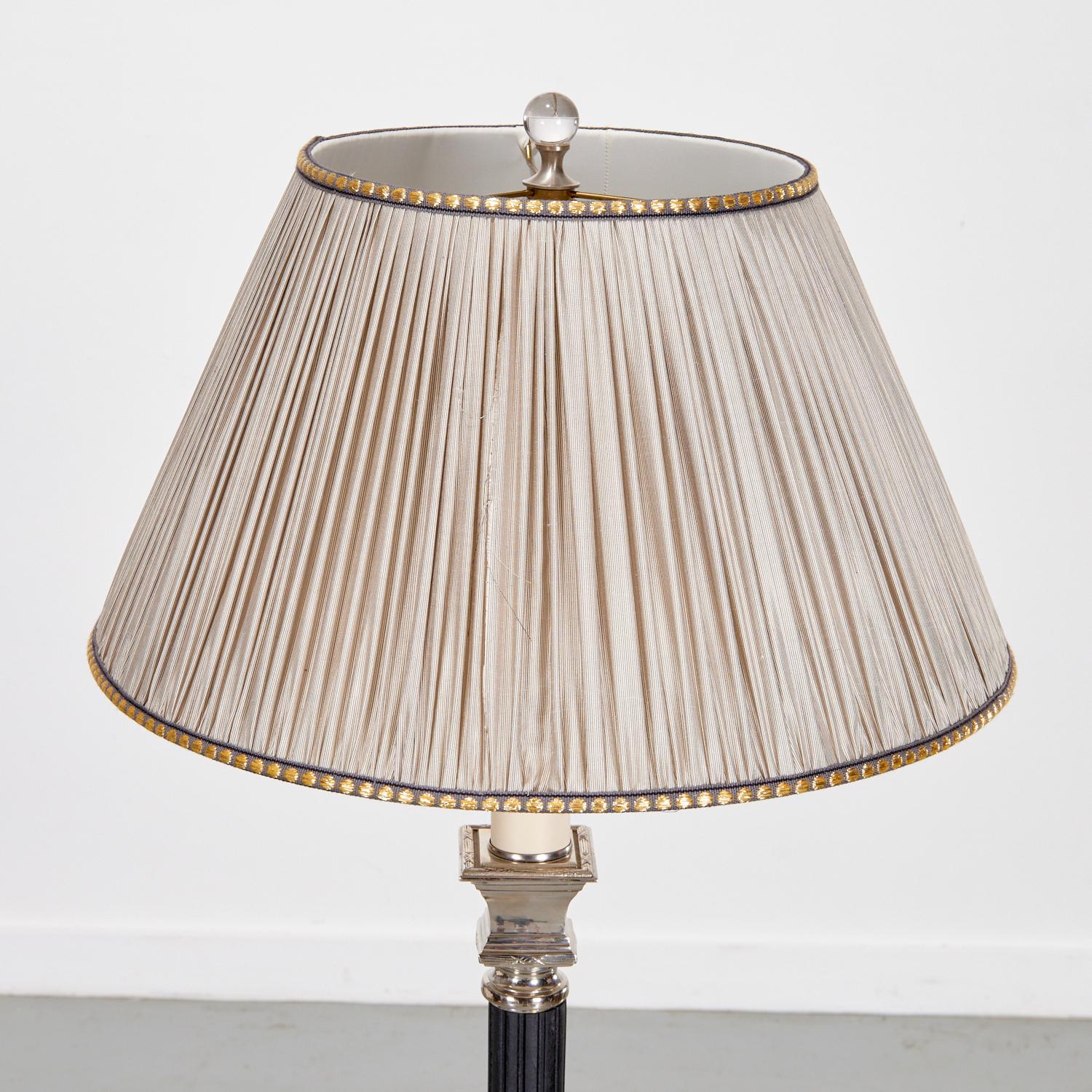 Lampada da terra della fine del XX secolo, caratterizzata da un design classico con una base a colonna scanalata nera e accenti argentati. La base a forma di piramide è intricata e dettagliata con strati a gradini che aggiungono un senso di