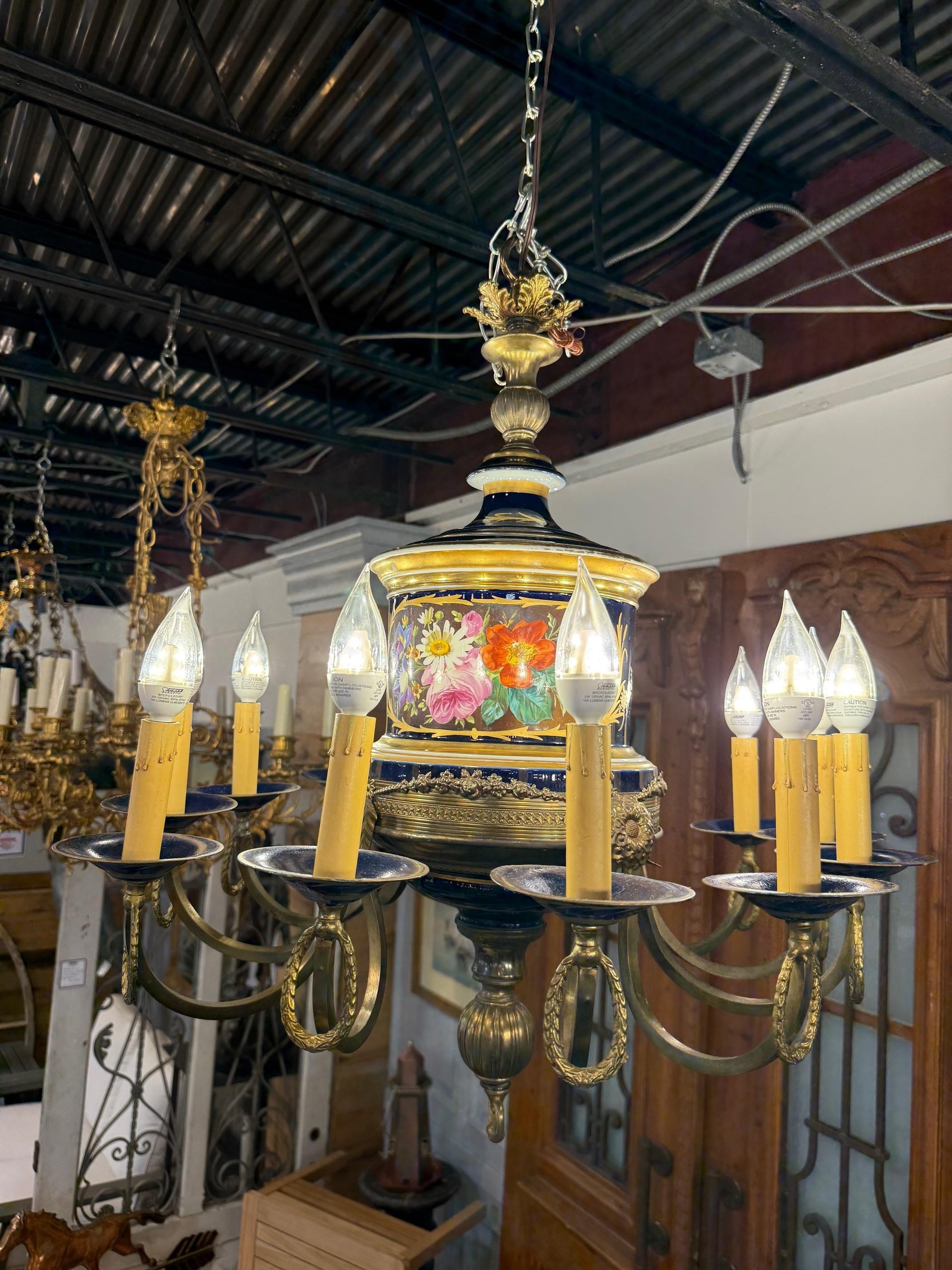 Late 20th Century French Limoges style cobalt blue porcelain and brass twelve light chandelier with beautiful hand painted floral decor. It features a large central porcelain body with hand painted floral designs, brass accents, and 12 arms holding
