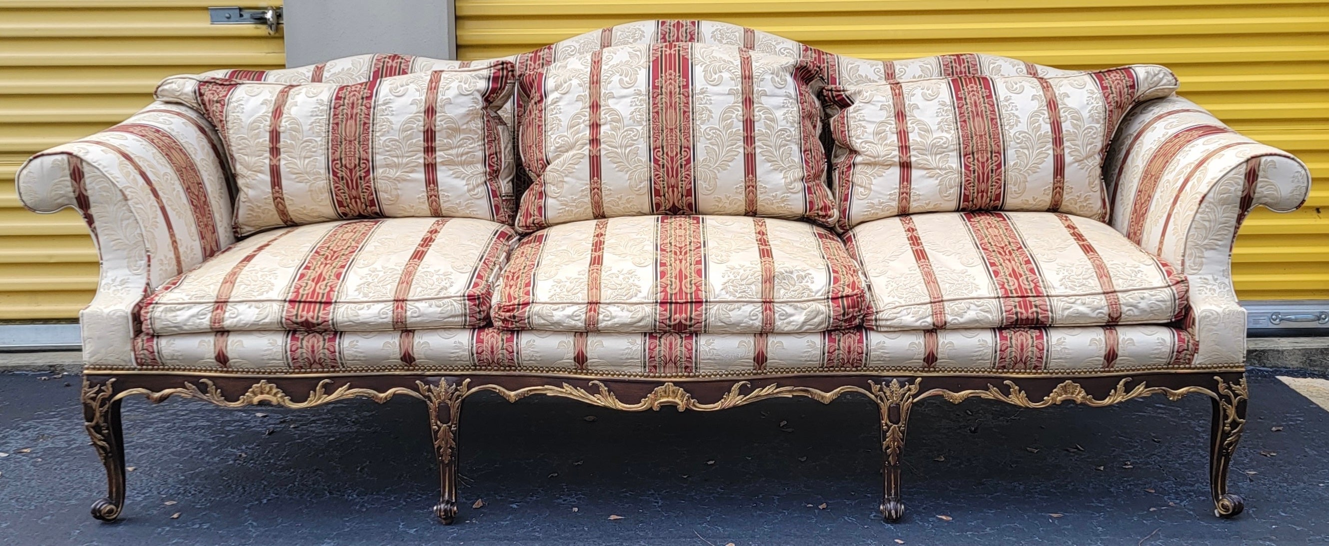 This is a late 20th century French Louis XVI style sofa by E.J. Victor. The piece is done in a stripe damask. It is shown with and without the loose cushions. It is marked. The carved fruitwood frame had gilt accents.