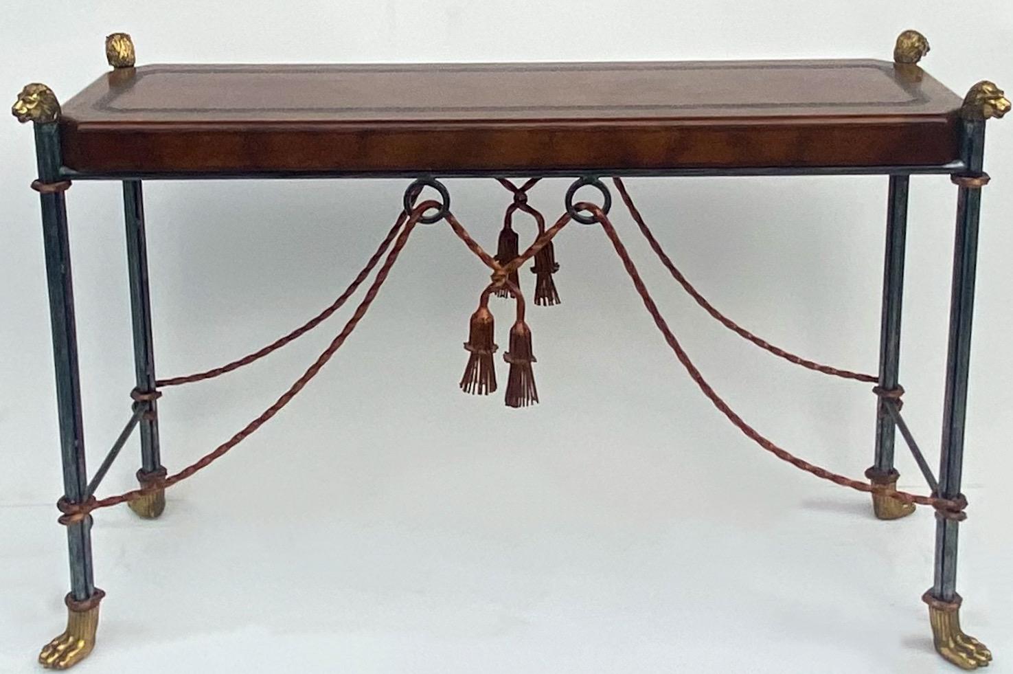 This is a late 20th century neoclassical style console table by Maitland-Smith. It has a tooled leather top and iron and brass base. The base has brass lion’s head and brass paws appointments. It is in very good condition.