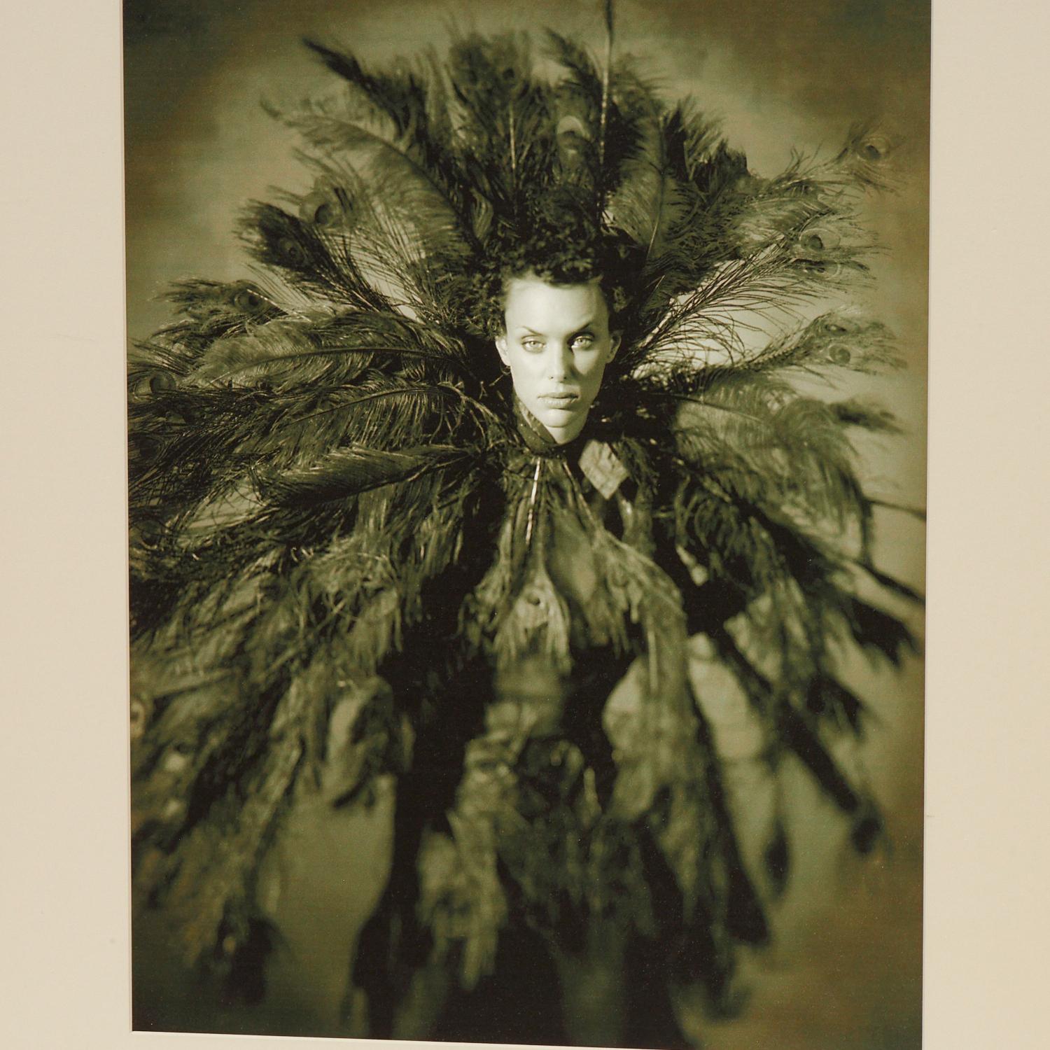 Late 20th C. a high quality giclee print on matte paper, pencil signed (illegibly) below matte and framed under glass. The subject is a very striking woman wearing a richly feathered garment. There is an ethereal almost haunting quality to this