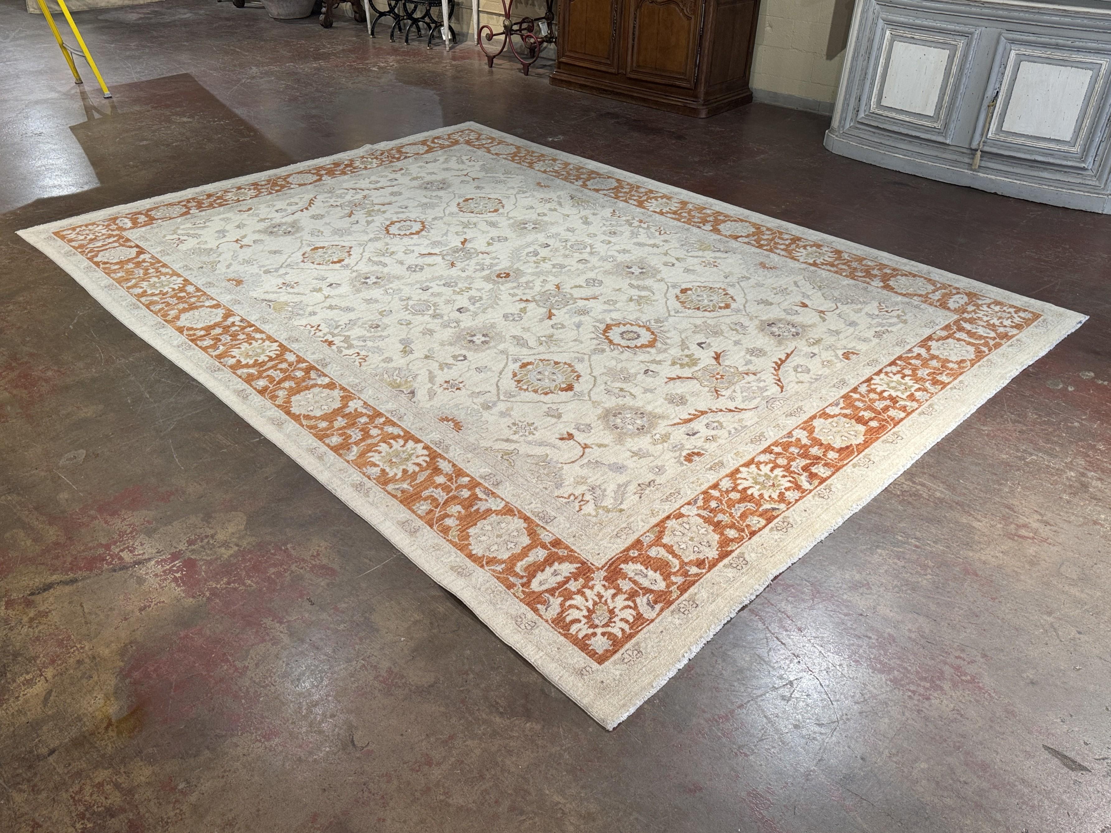 Crafted in Turkey in the late 20th century, this large hand-knotted wool rug showcases the refined elegance of the Oushak weaving tradition. Measuring 164 inches long by 119 inches wide, the carpet features a warm ivory field adorned with an allover