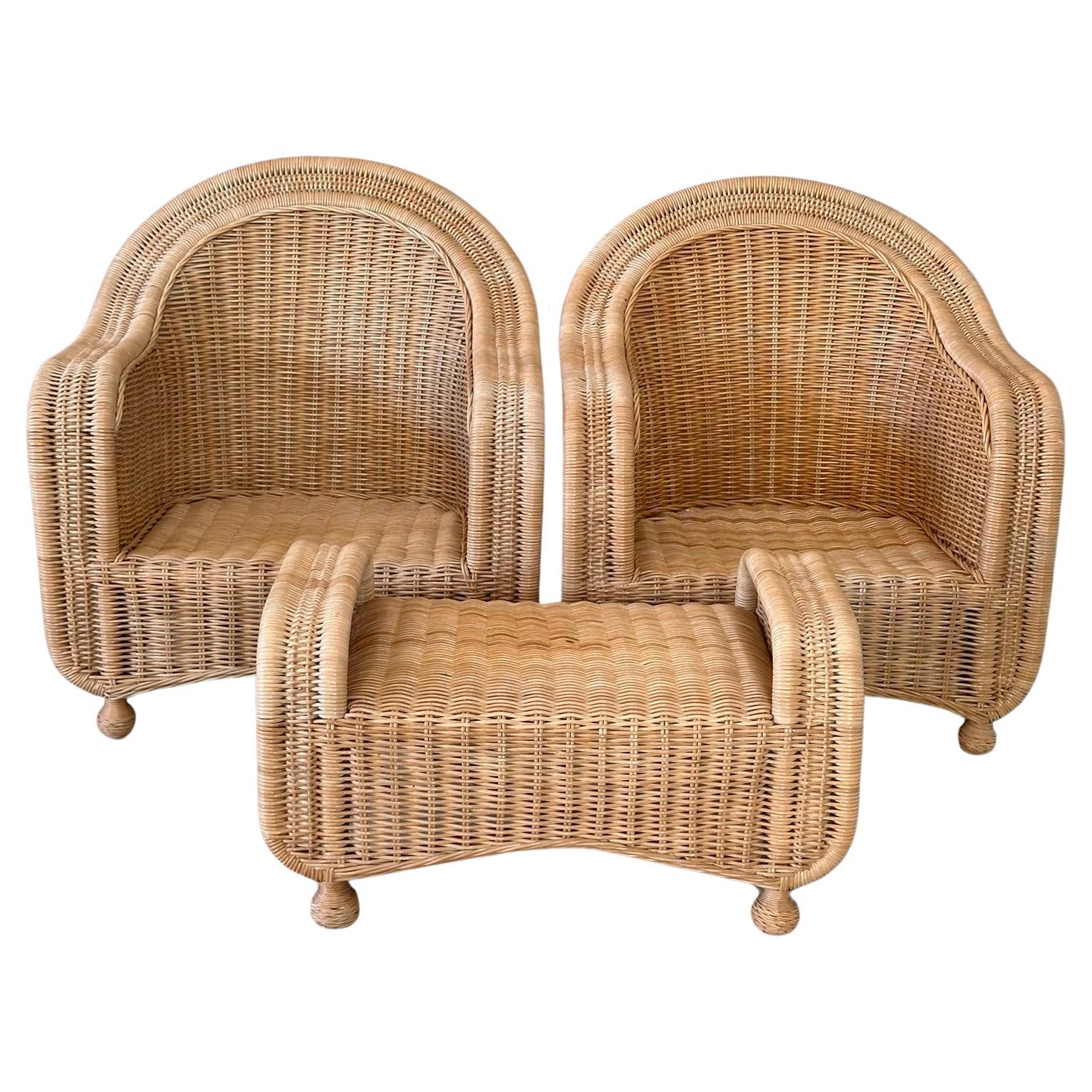 Elevate your coastal or tropical-inspired space with this stunning pair of 1980s rattan lounge chairs and matching ottoman. Expertly crafted from durable rattan, these pieces feature a curvaceous design and ball feet, exuding both comfort and