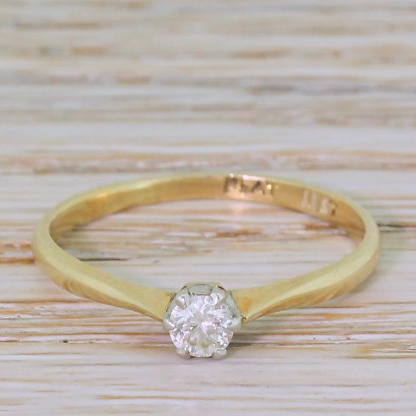 A classy vintage diamond solitaire. The round brilliant cut diamond is white and internally clean, and is secured in a platinum six claw coronet collet which sits on a slim and tapering 18k yellow gold shank.

Cut – Round brilliant cut.

Colour –