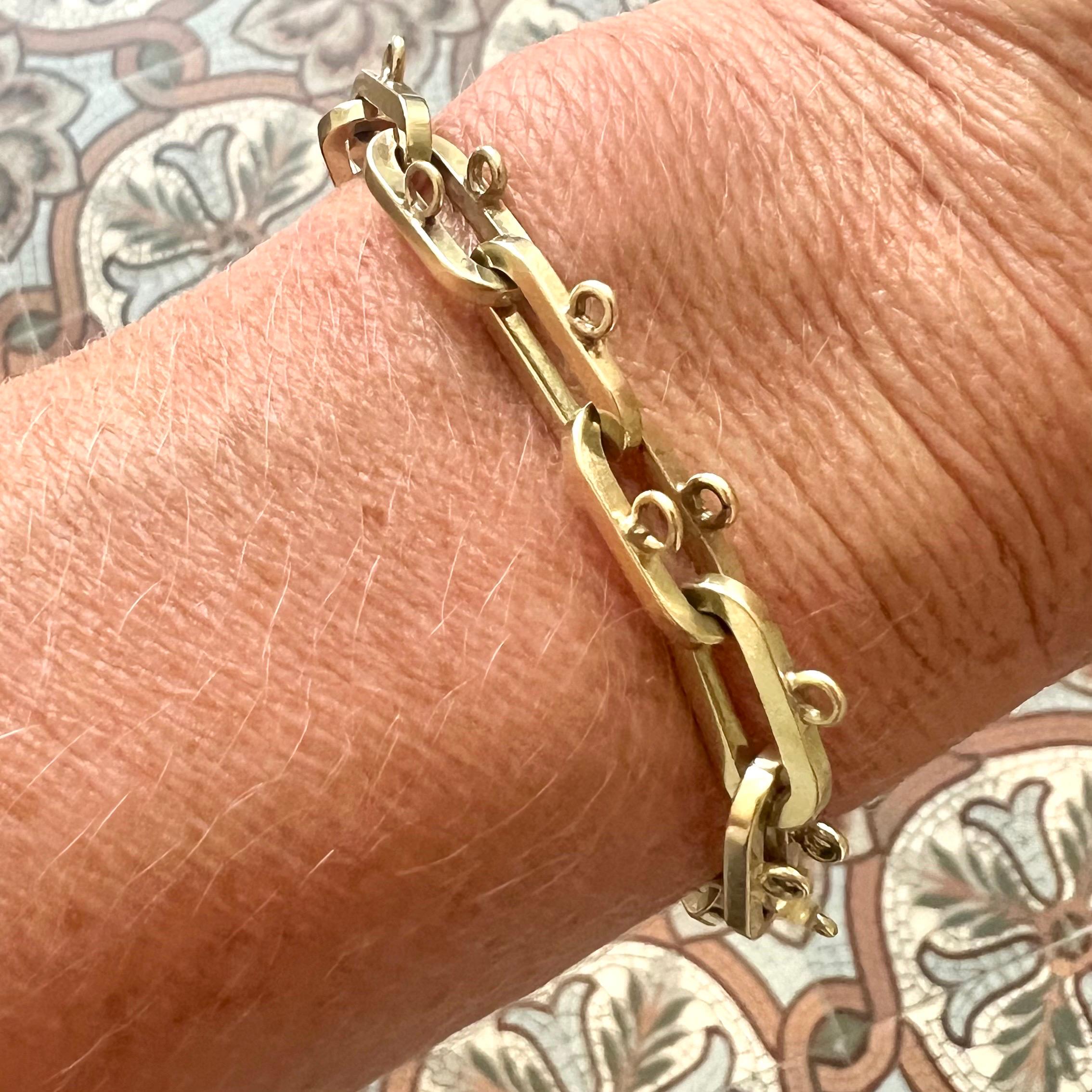 Un bracelet vintage substantiel et polyvalent, fabriqué en or jaune 14 carats massif à la fin du 20e siècle. Le design est composé de maillons rectangulaires allongés et audacieux, chacun équipé de petites boucles soudées destinées à la fixation de