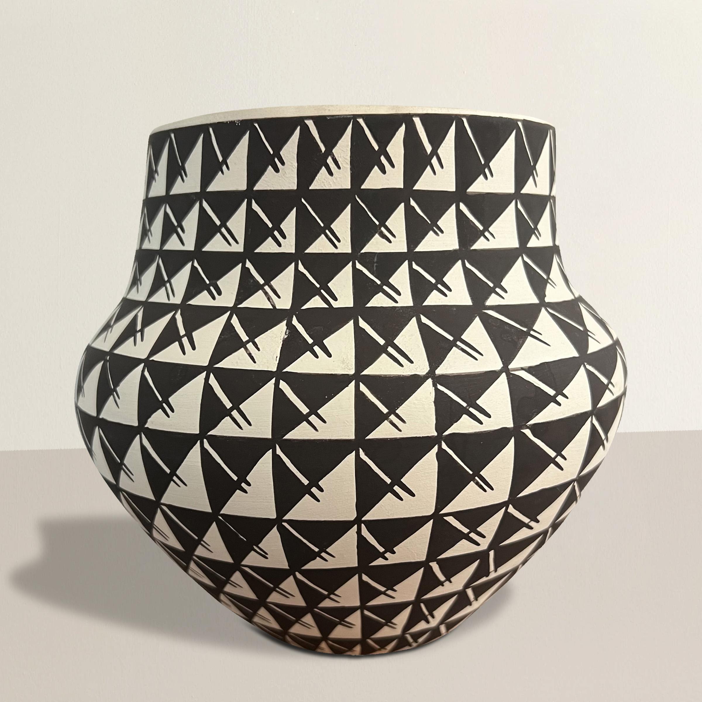 Questa ciotola in ceramica del Pueblo di fine XX secolo è un esempio lampante della maestria e dell'artigianato sinonimo di ceramica Acoma. Dipinta a mano con un meticoloso motivo a griglia in bianco e nero che copre l'intera superficie, la ciotola