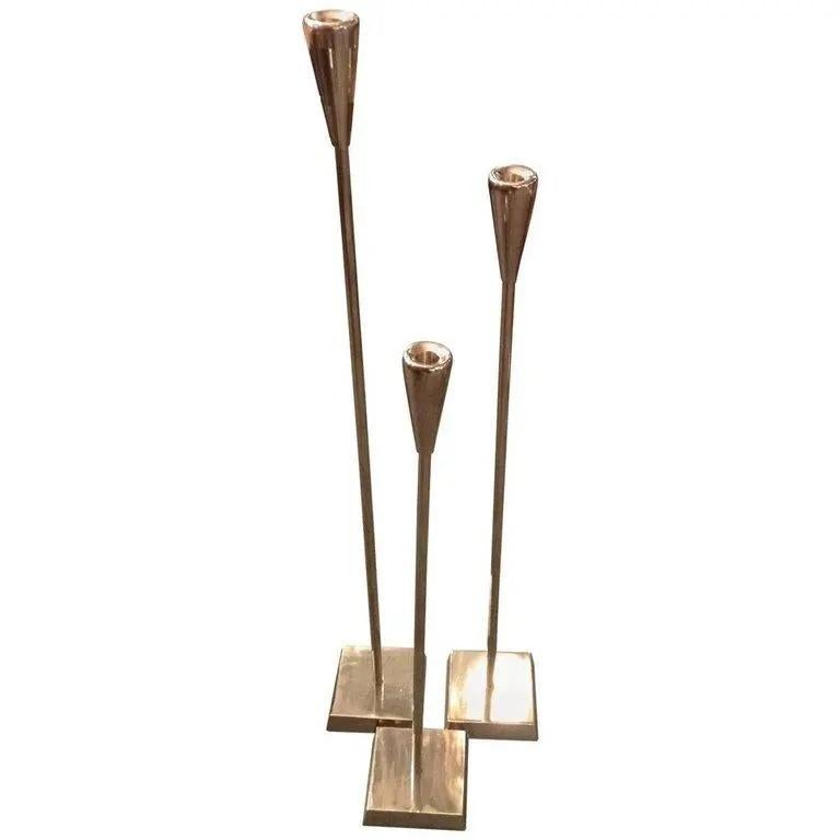 Modern and elegant, this trio of tall, slender candle sticks will be the perfect touch beside a master bathtub or gathered on a fireplace hearth. Fashioned from aluminum, of varying heights, the polished silver finish gives them an extra dose of