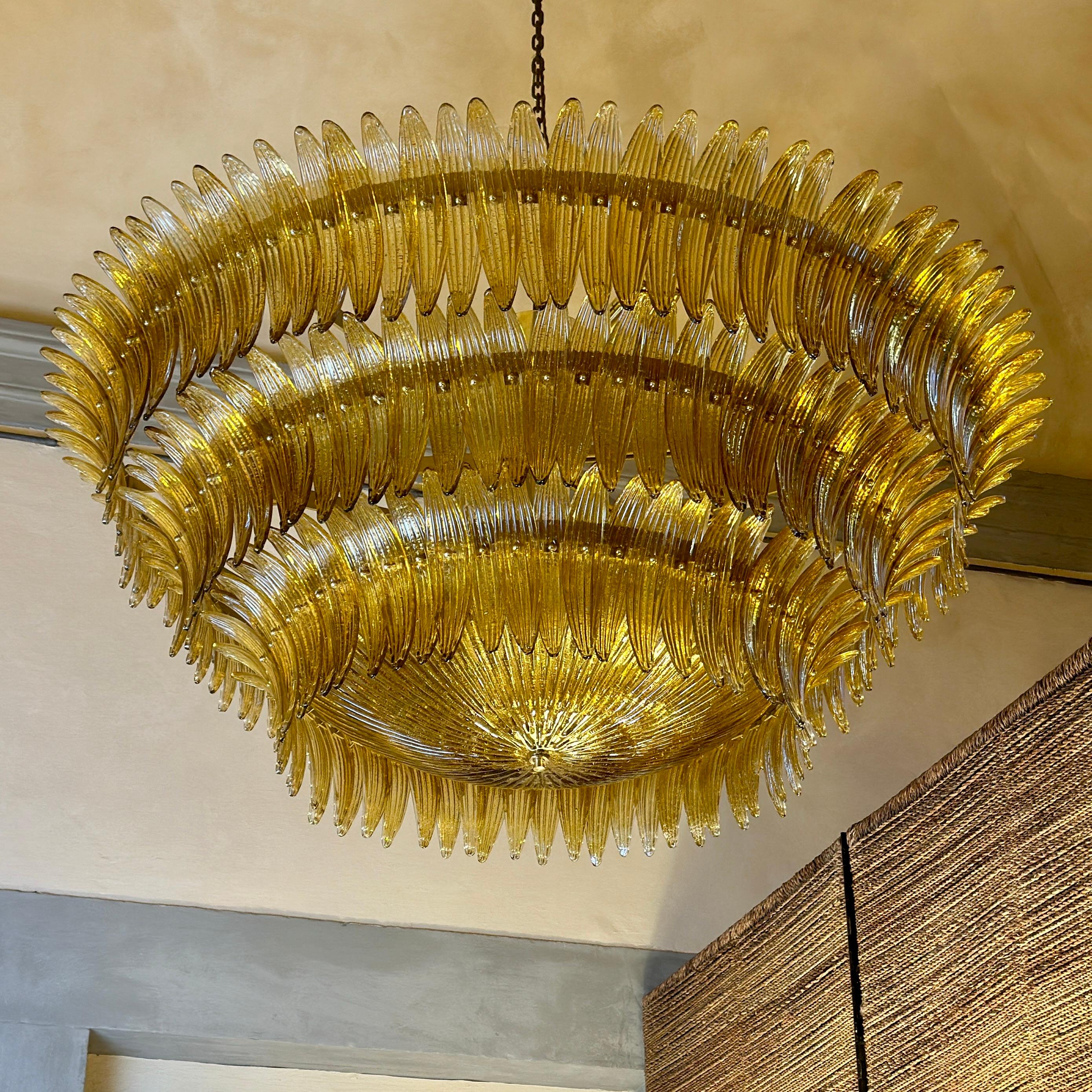 Monumental amber palmette glass with gold glittering and bottom round ribbed glass to close the round chandelier by Barovier & Toso. 
White painted iron structure with brass finishings and 36 E14 Light Bulbs with warm light recommended. Eventual
