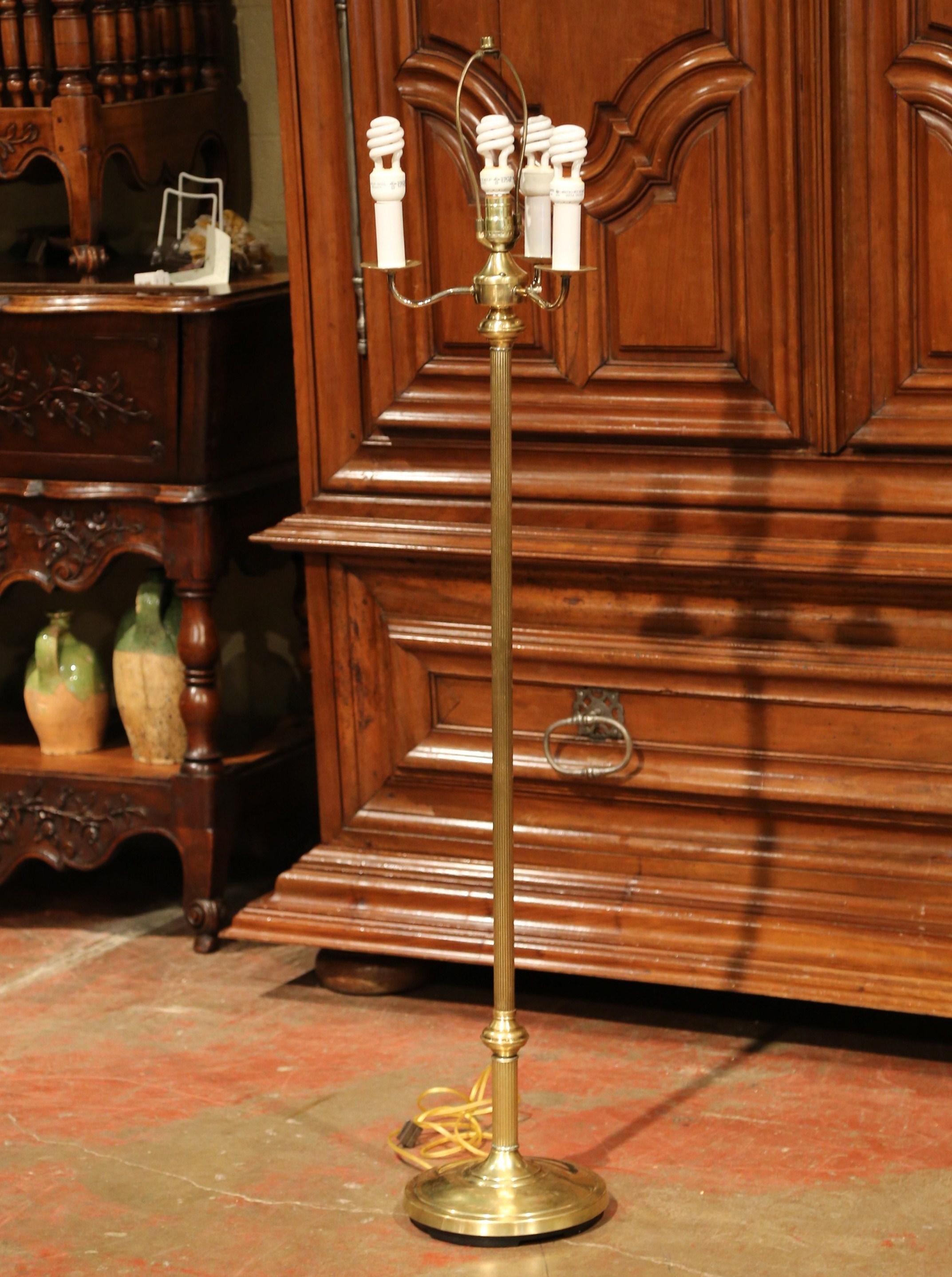 This elegant, vintage floor lamp was crafted in America, circa 1970. The simple, traditional light features a circular brass base with a long decorated stem. The lamp has been rewired with a four-bulb device including a center light, with double