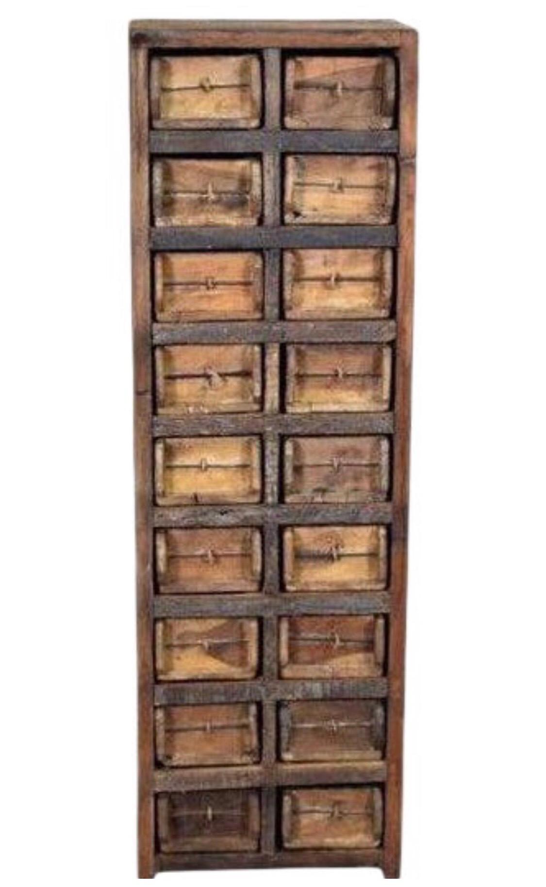 This rectangular wooden cabinet features storage cubbies that house eighteen rectangular drawers that are made from vintage reclaimed wood.