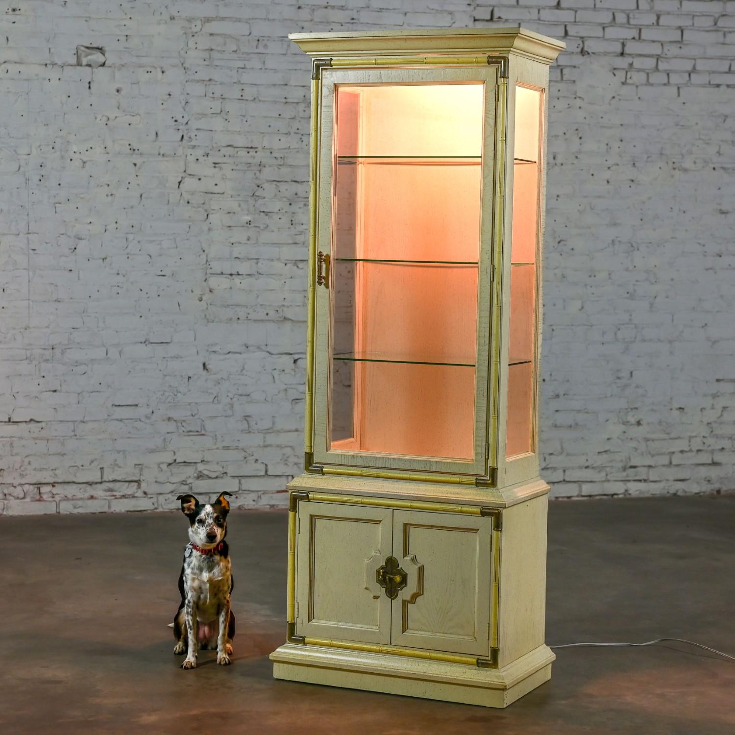 Graziosa vetrinetta illuminata d'epoca in stile Asian Chinoiserie & Campaigner con 3 ripiani fissi in vetro, dettagli angolari in ottone e ferramenta nello stile di Drexel. In ottime condizioni, tenendo presente che si tratta di un prodotto vintage