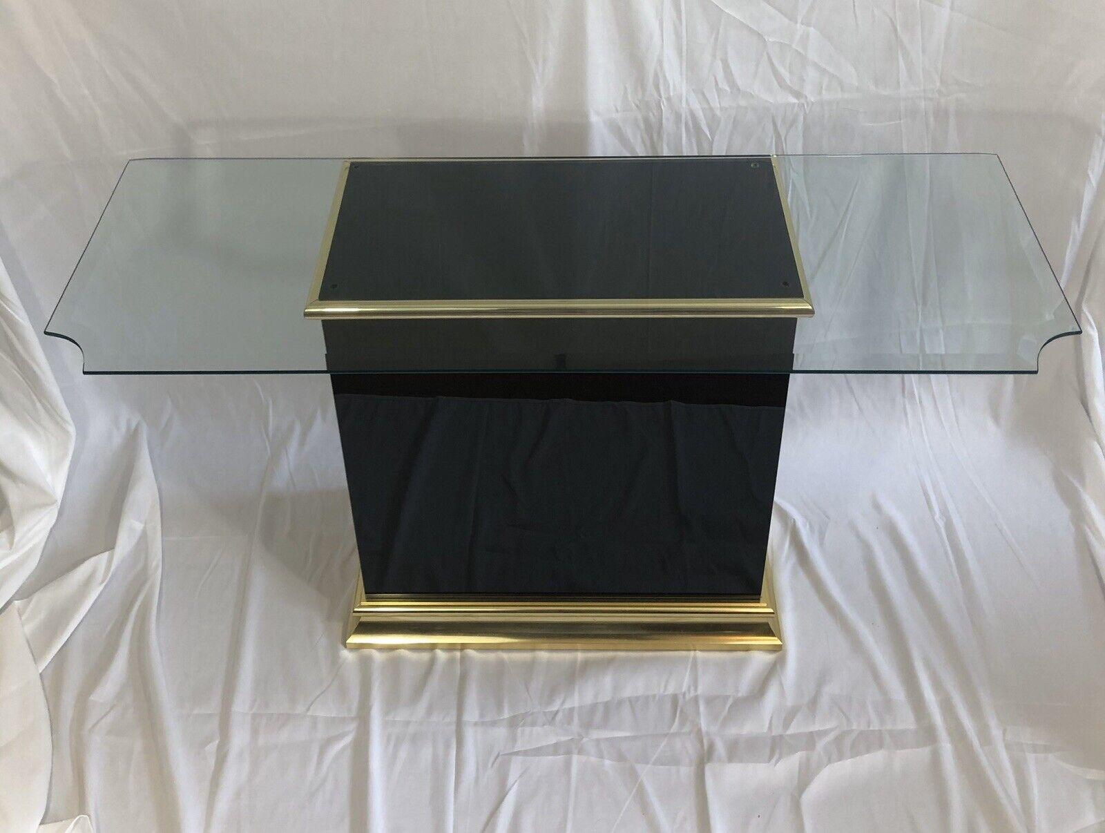 Stunning black glass console table with polishes brass trim. Beveled glass top with notched corners for a sophisticated profile. 3/4 finish.
Base measures:
27.5T x 25.25W x 14D
Glass measures
50x18
Curbside to NYC/Philly available $300.