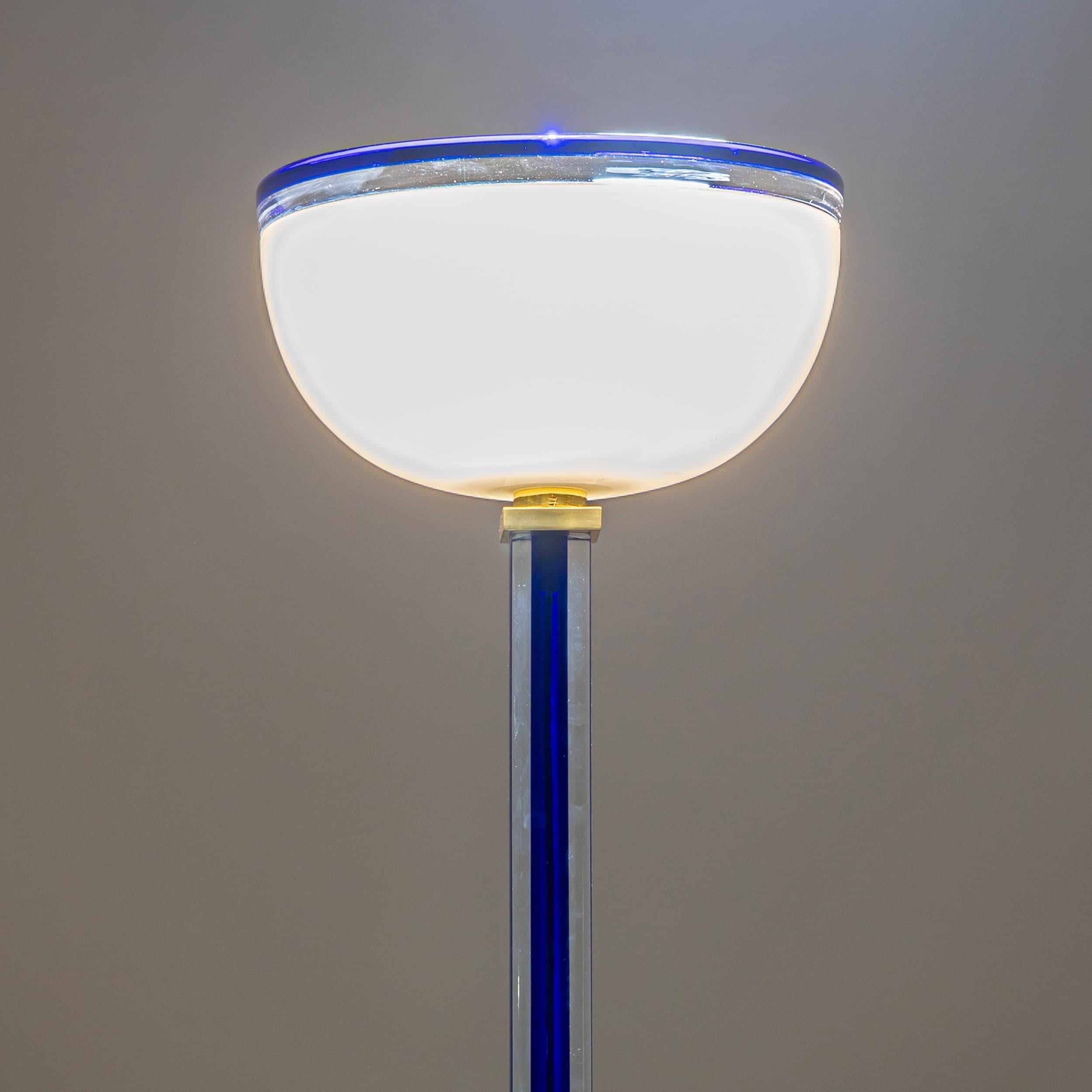 Elegant, tall “Tolboi” floor lamp by Venini, made in Italy in the 1980s. The slender shaft crafted from deep cobalt blue Murano glass supports a hemispherical lampshade made of white opaline glass. The lamp stands on a polished square brass base.