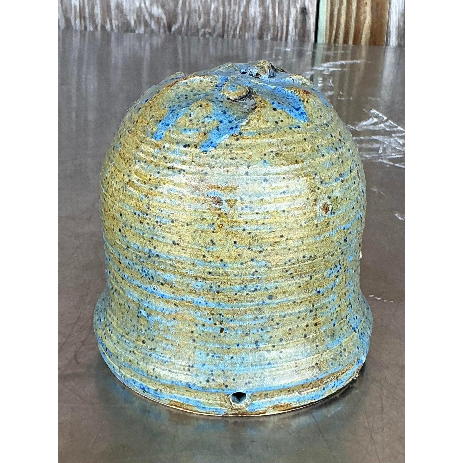 Bring the warmth of handcrafted artistry into your home with this exceptional vintage studio pottery planter. This unique piece showcases a beautiful blend of organic form and rustic charm, featuring a distinctly textured, ribbed exterior that runs