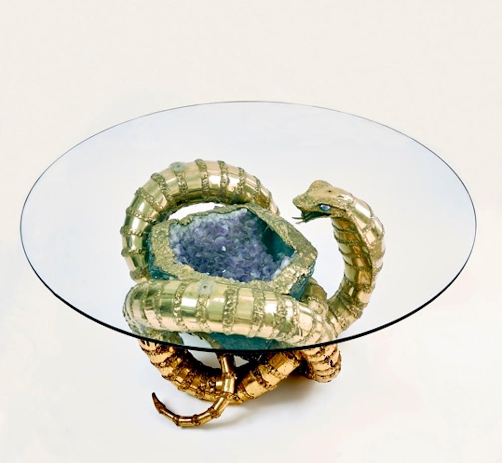 Late 20th century brass cobra snake sculptural coffee table with a large amethyst crystal cluster tightly held in the snakes could. Beautifully crafted in sheet brass and solder the Cobra's expression is very lifelike and with a blue stone set in