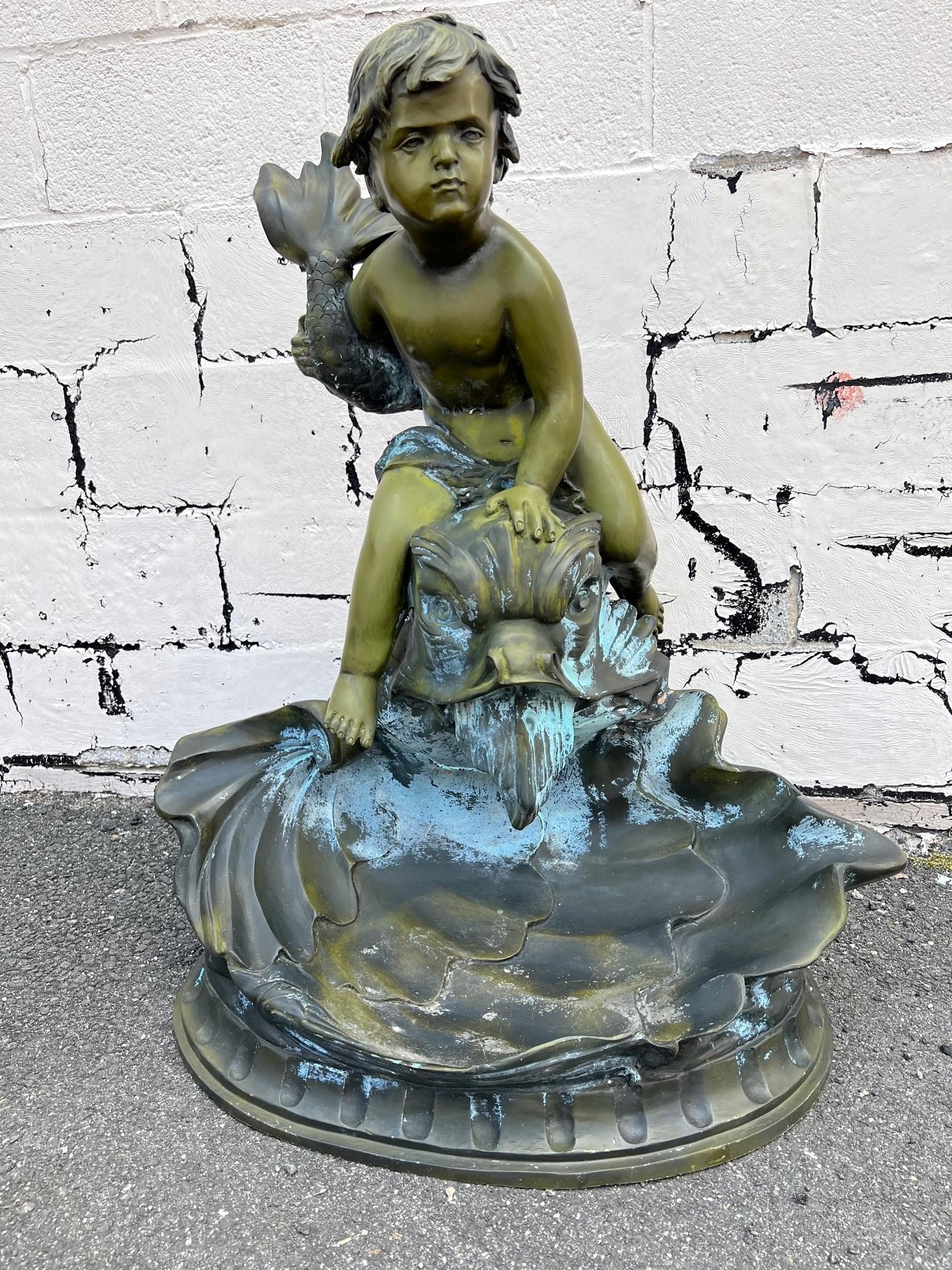 Vintage bronze fountain from the late 20th century, depicting a putto riding a dolphin fish on top of a large clam shell. Created with the traditional technique of the lost wax that allows a great precision and finesse in the details. This fountain
