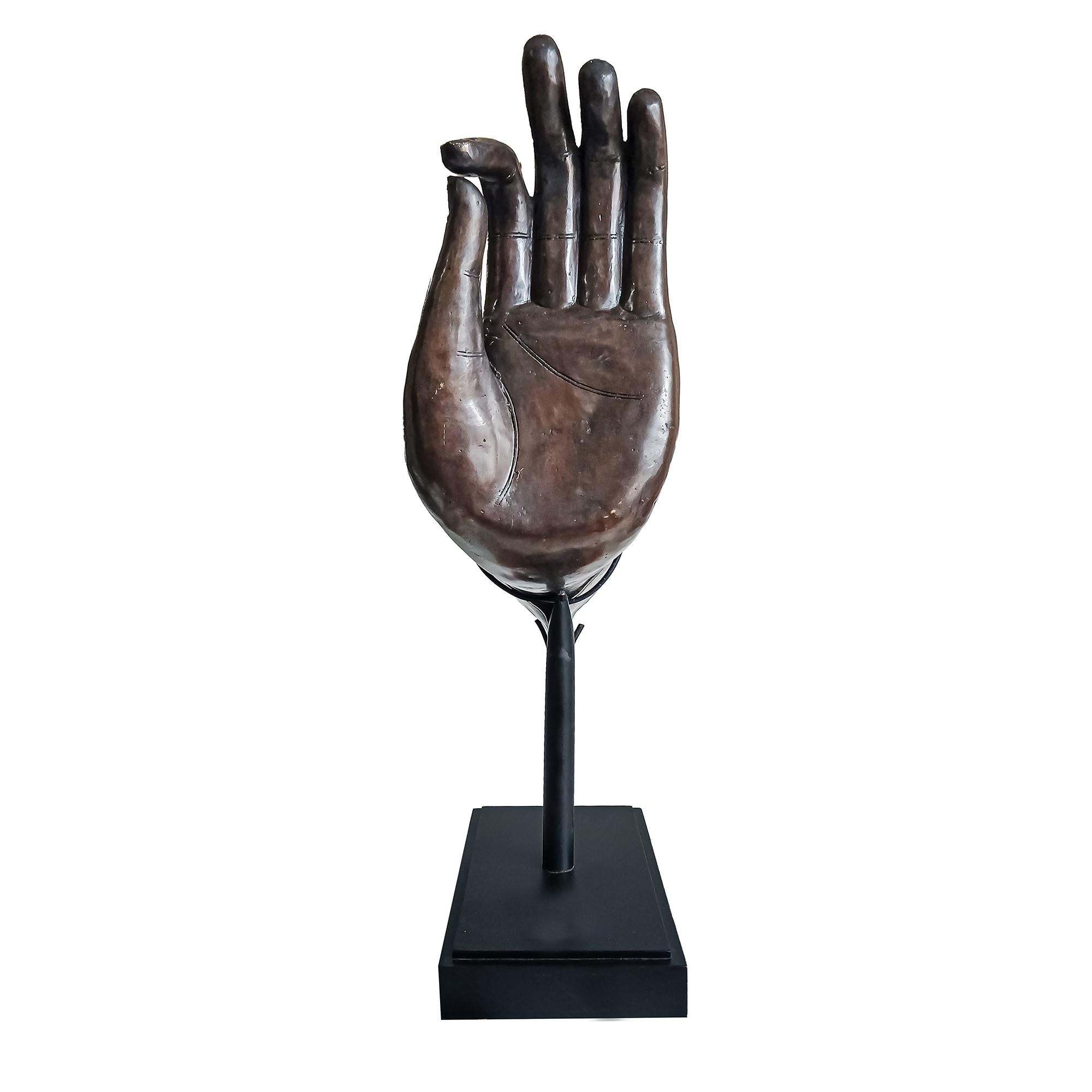 A large cast bronze sculpture of a Buddha's left hand. Indonesia, circa 1980. Dark brown patinated finish. 

The gesture is known as Dharmachakra Mudra, the traditional Buddhist gesture of teaching and discussion. This artistic representation