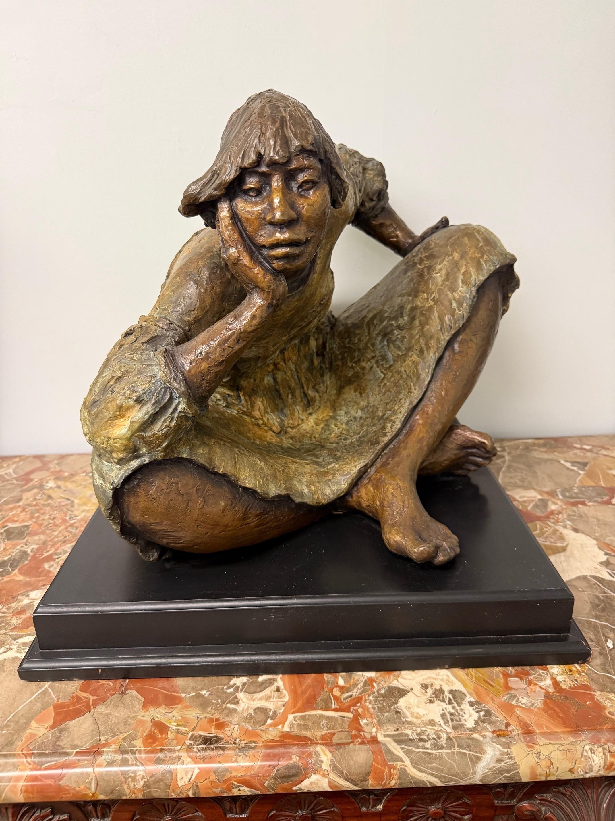 Late 20th century bronze sculpture called Navajo Woman by Shirley Thomson Smith. Smith was inspired by the strength and character of Native American women. This particular sculpture is a depiction of a woman sitting on the ground, in thought, with