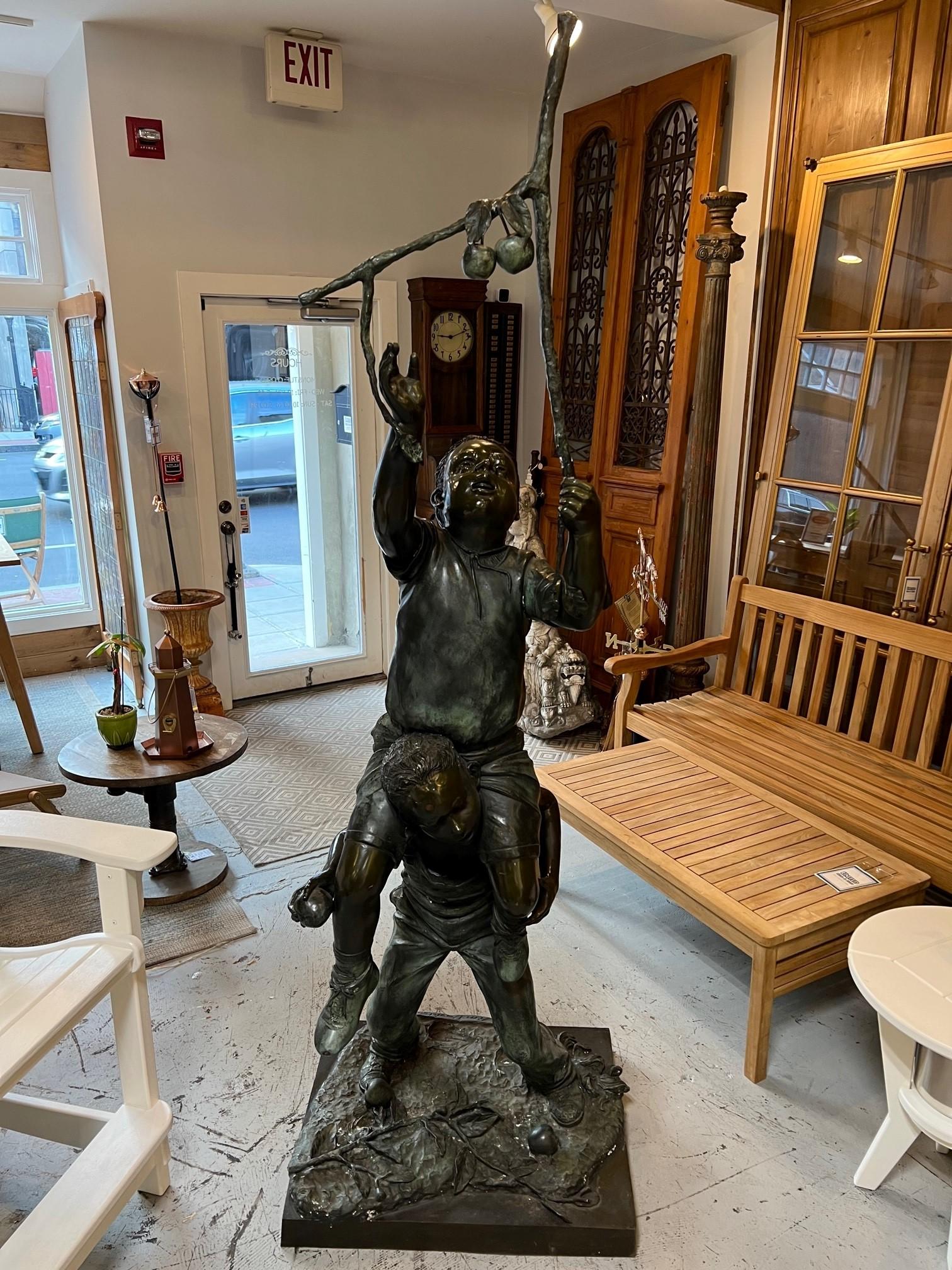 Late 20th century bronze statue of two boys trying to pick apples. This is a fun bronze that would look great in any garden or yard. The bronze does have some scuff marks and scratches but overall in good condition. It does have a signature Jim