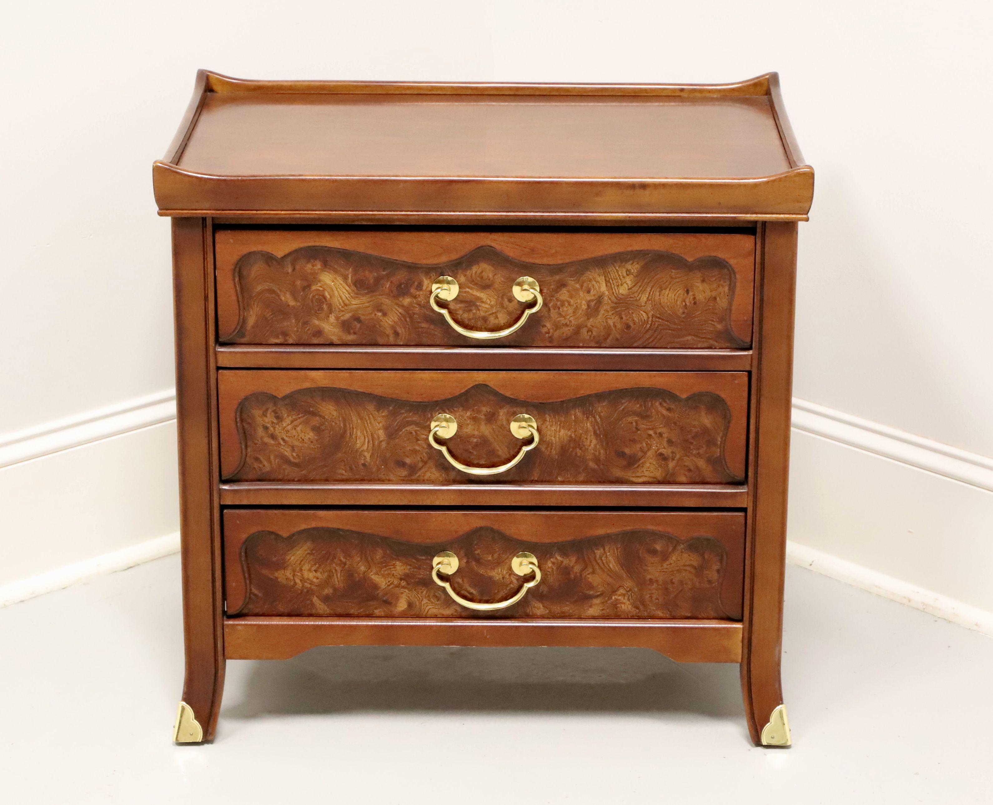 An Asian inspired nightstand, unbranded, similar quality to Henredon. Walnut with slightly distressed finish, brass hardware, raised gallery top, burlwood to drawer fronts and brass accents to feet. Features three drawers of dovetail construction.