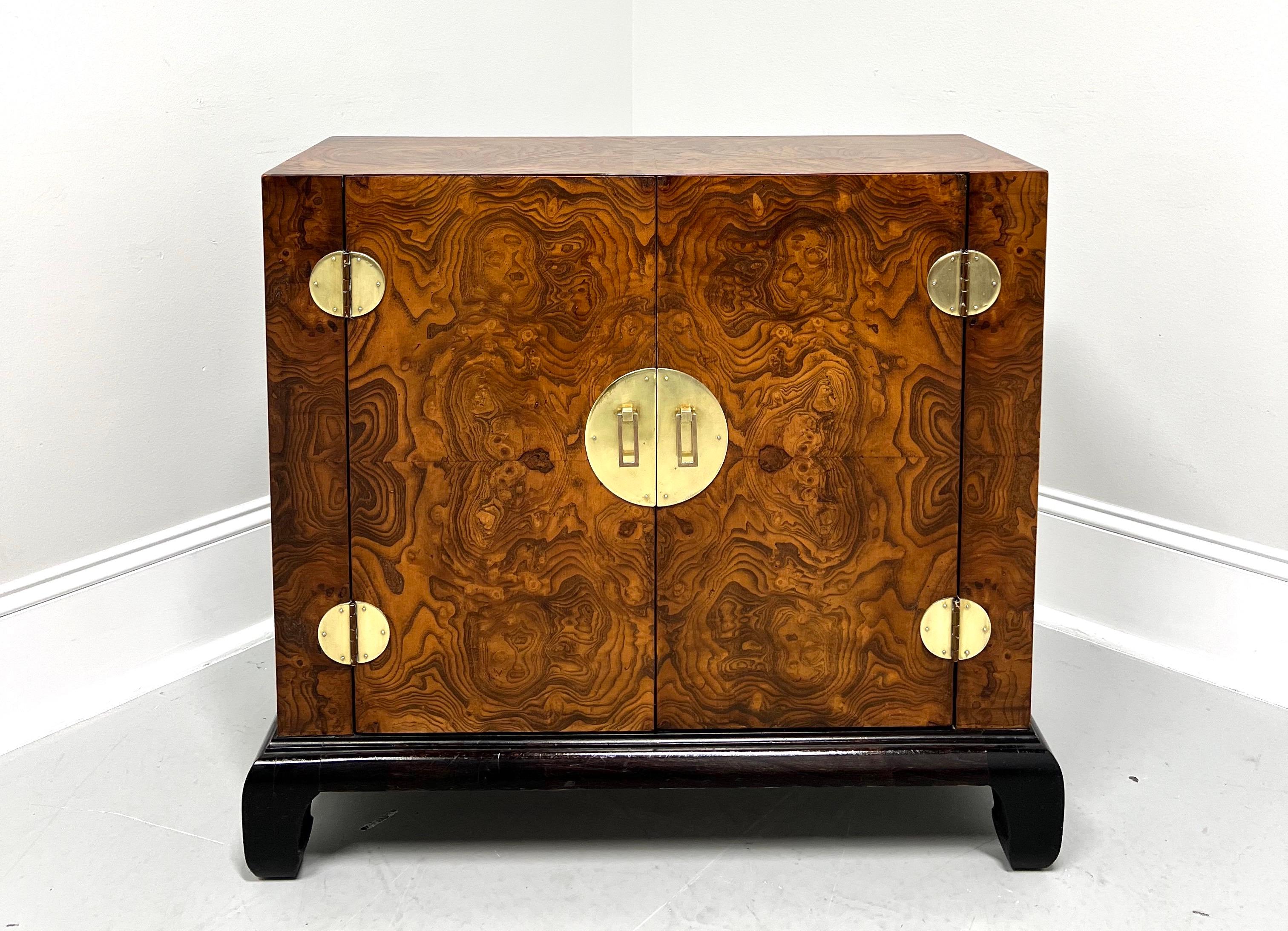 An Asian Ming style narrow console cabinet, unbranded. Burlwood with smooth surface top, brass hardware & accents, and Ming style black lacquered feet. Features two doors revealing interior storage with one fixed wood shelf. Likely made in the USA,