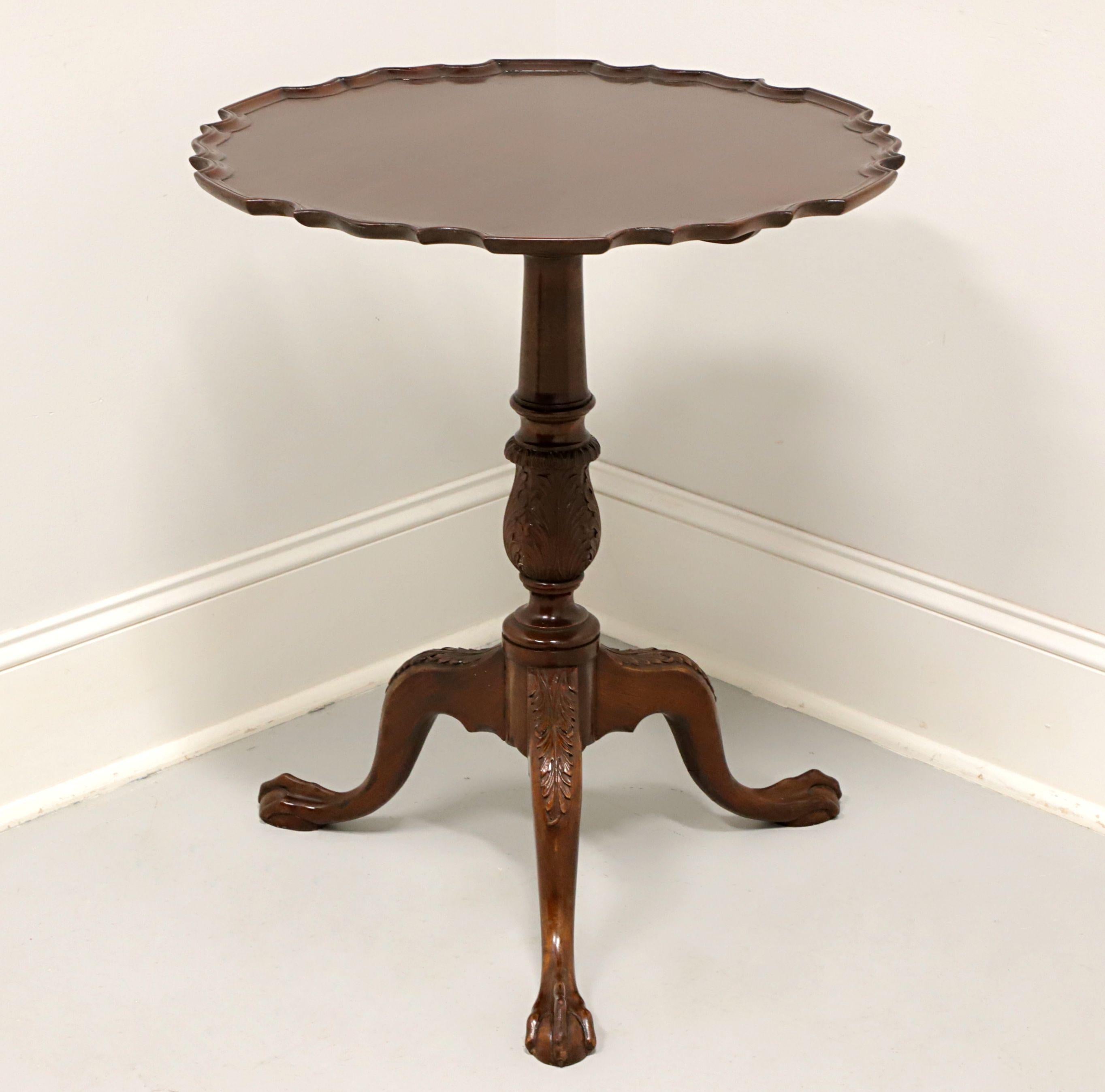 A Chippendale style tilt-top pie crust table, unbranded, similar quality to Craftique or Henkel Harris. Solid mahogany with scalloped edge top, tilt mechanism, brass latch, turned & fluted pedestal, three legs with acanthus leaf carved knees, and