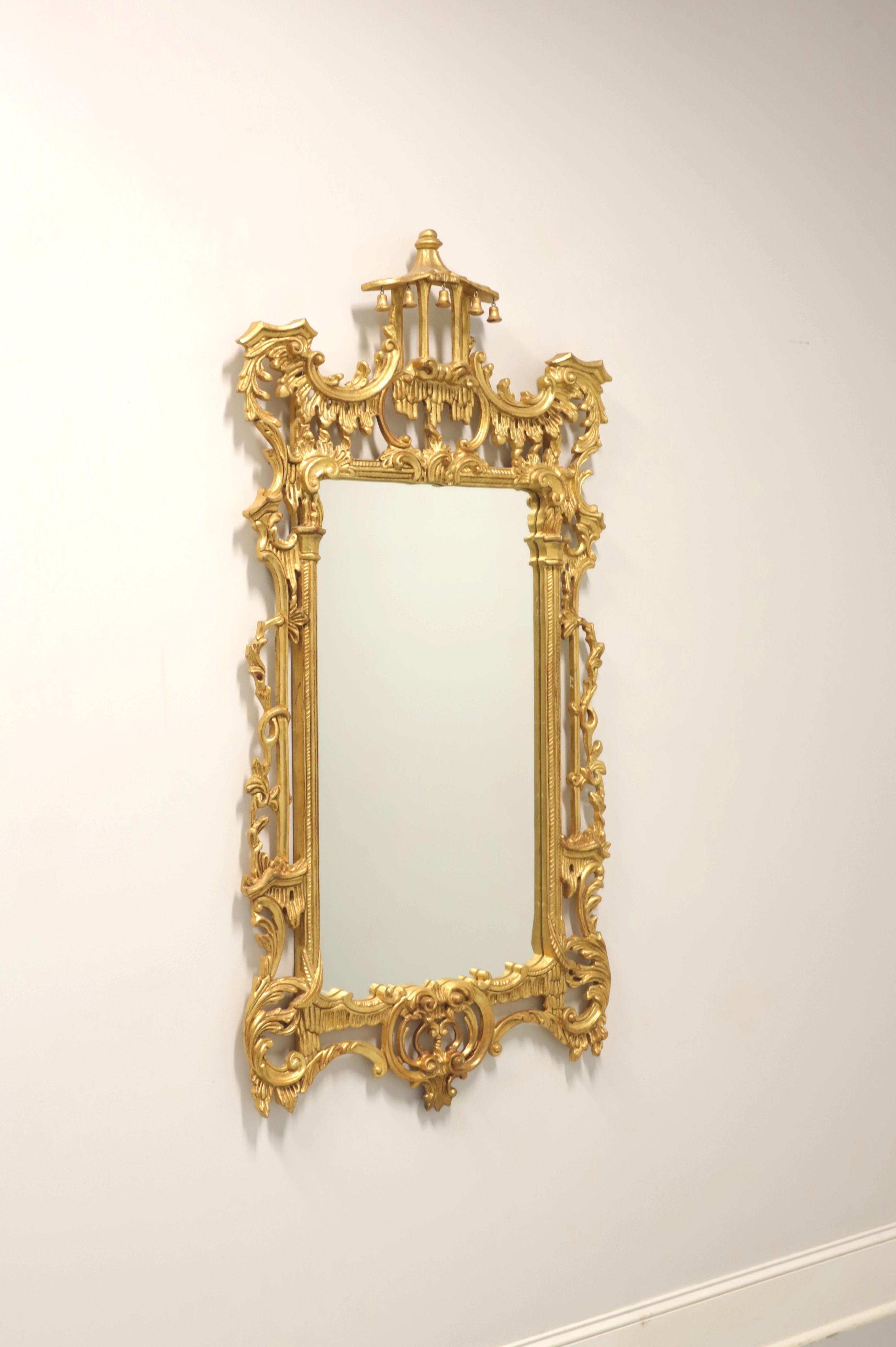 A wall mirror in the Chinese Chippendale style by Labarge. Mirror glass in an intricately carved gold gilt painted wood frame. Features a very decorative design with a carved pagoda to the top center. Made in Italy, in the late 20th