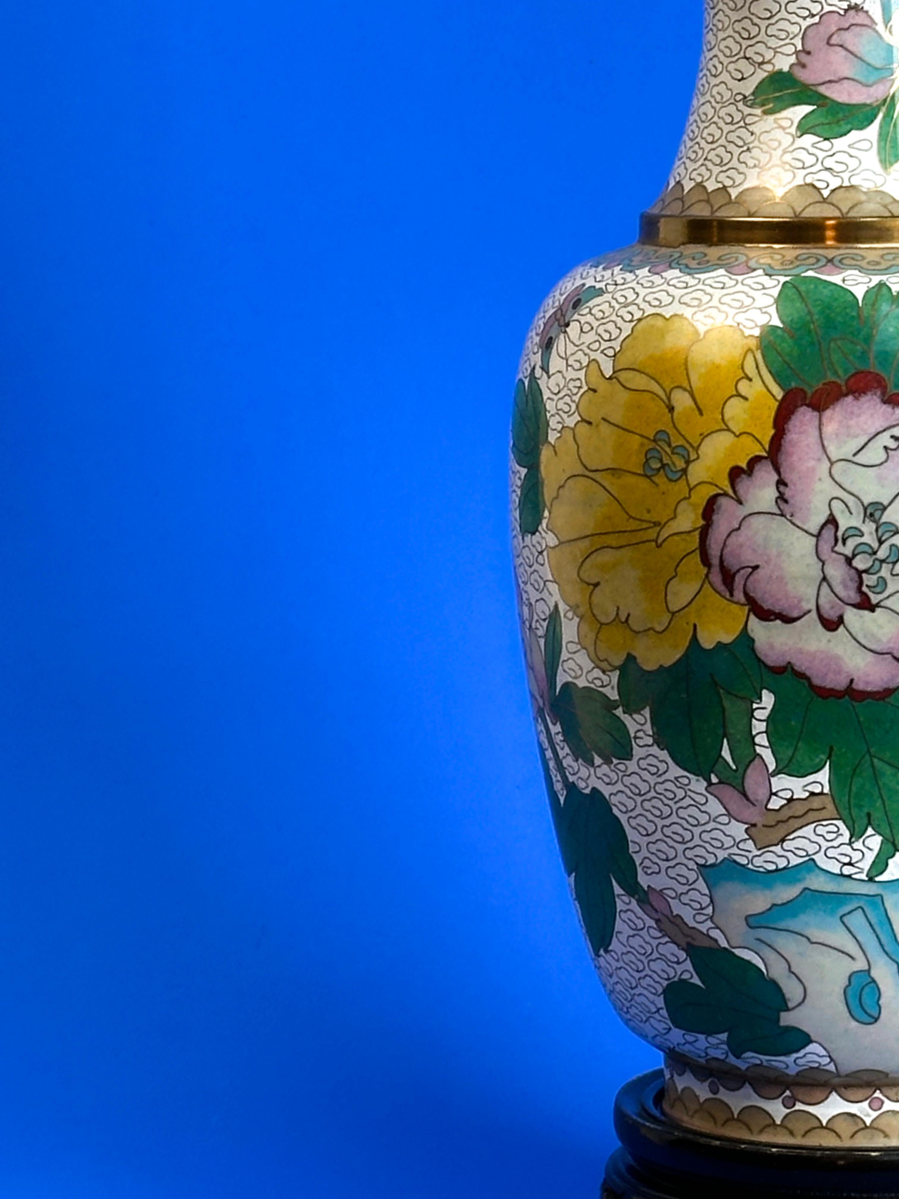 Vintage Chinese Cloisonné Vase

A brass-crafted, baluster-shaped cloisonné vase featuring vibrant floral and butterfly motifs on a crisp white enamel background, complete with a hand-carved wooden plinth.

Key Points:

Brass base with detailed brass