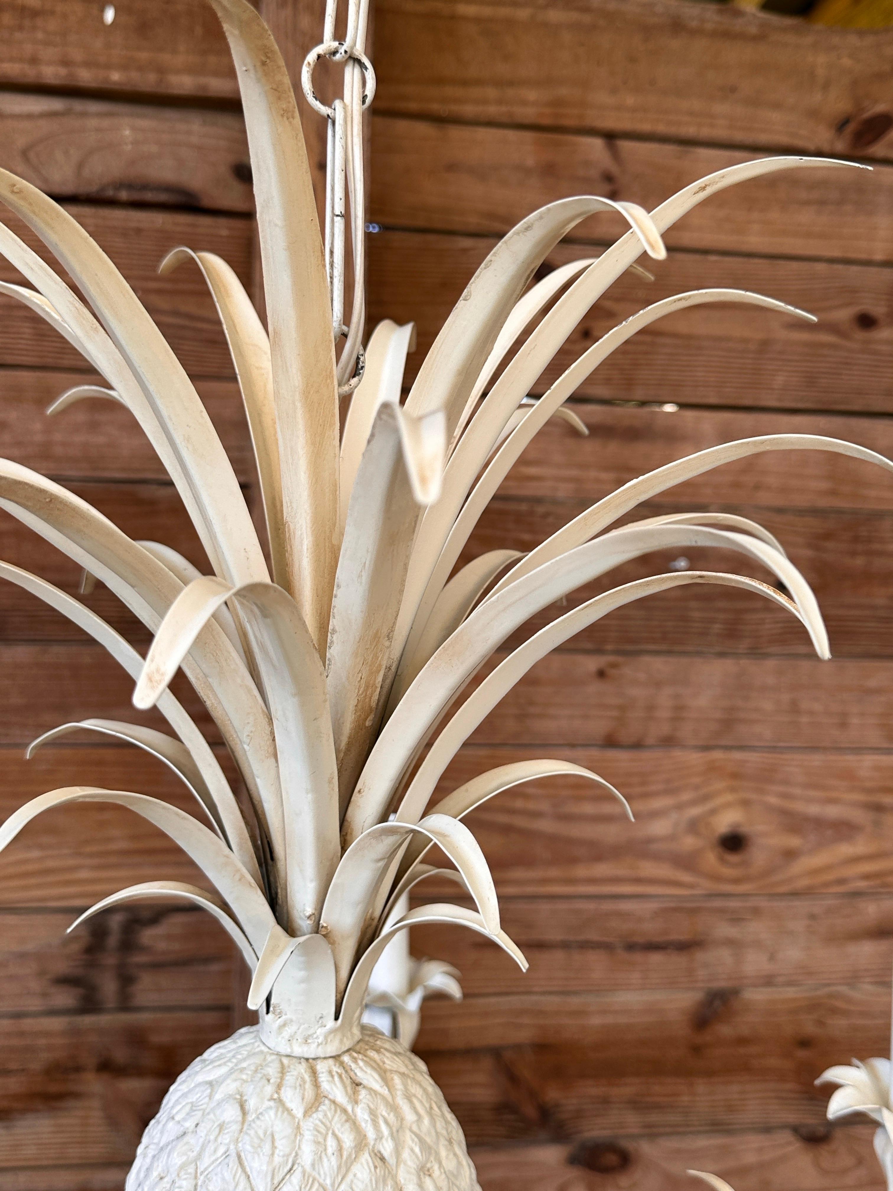 This striking late 20th-century Italian tole chandelier features a bold pineapple centerpiece, symbolizing hospitality and warmth.
Crafted with intricate detailing, the painted metal leaves radiate upward and downward, adding dynamic movement and