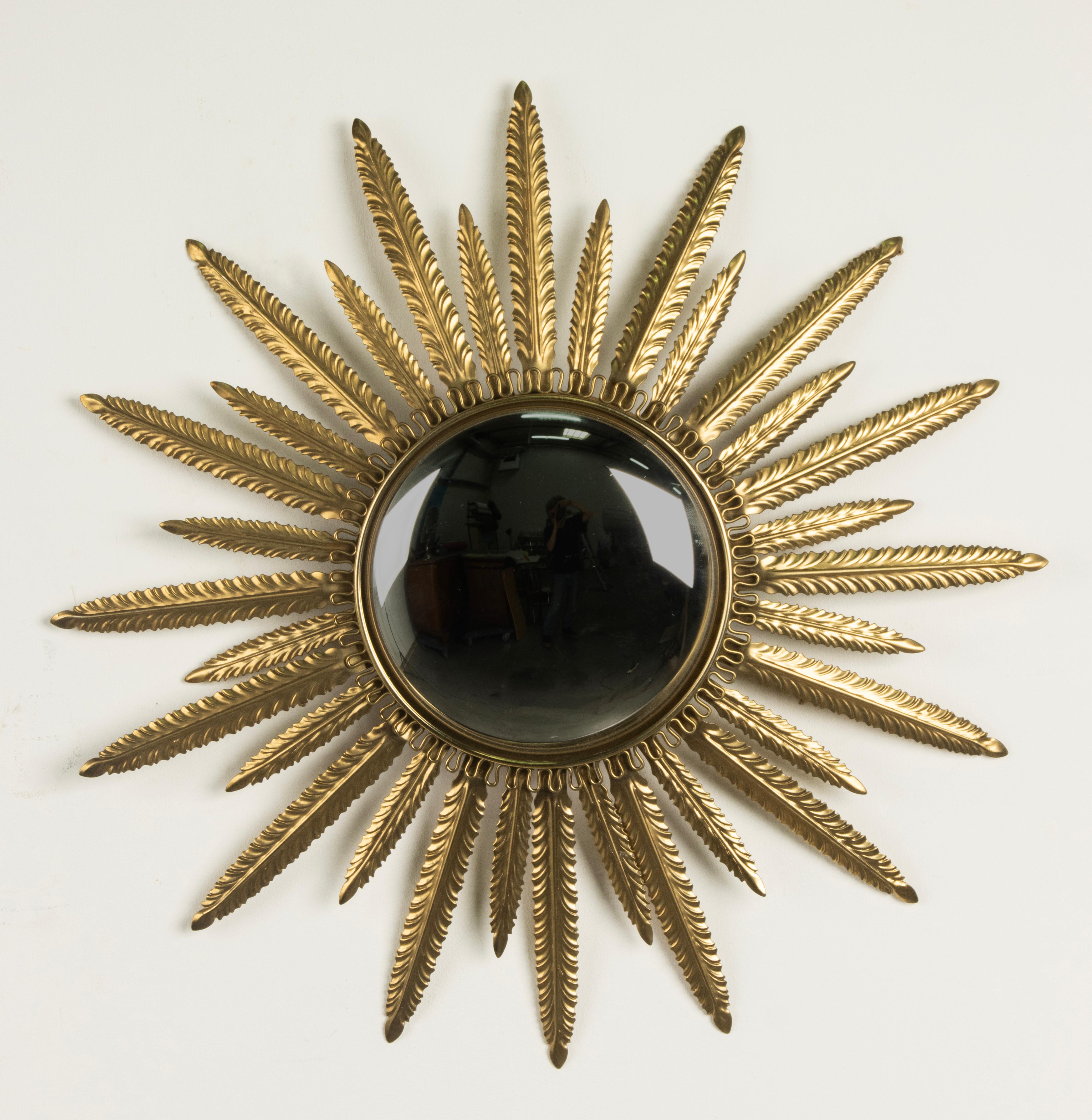 A Mid 20th century foliate sunburst convex mirror. Made of copper-colored patinated metal. Attributed to DeKnudt Mirros, made in Belgium around 1960-1970. The glass is in good condition, no cracks or damages. Small scratches on the