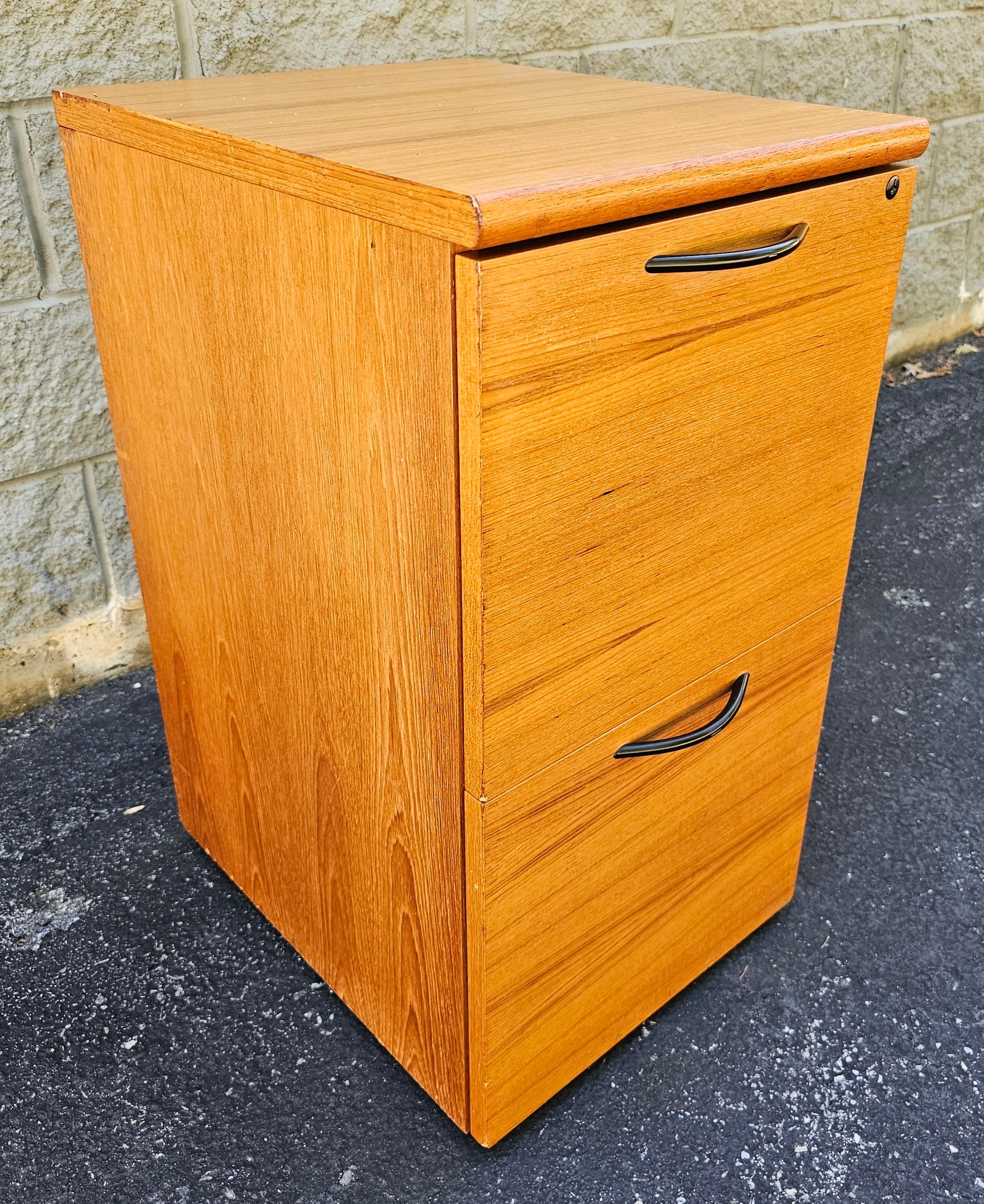 A Late 20th Century Danish Modern Teak Two-Drawer Rolling Filing Cabinet attributed to Bent Silberg Mobler. 
Built-in file folders rails and 5 rolling casters. Very good vintage condition. Key not present. Measures 16