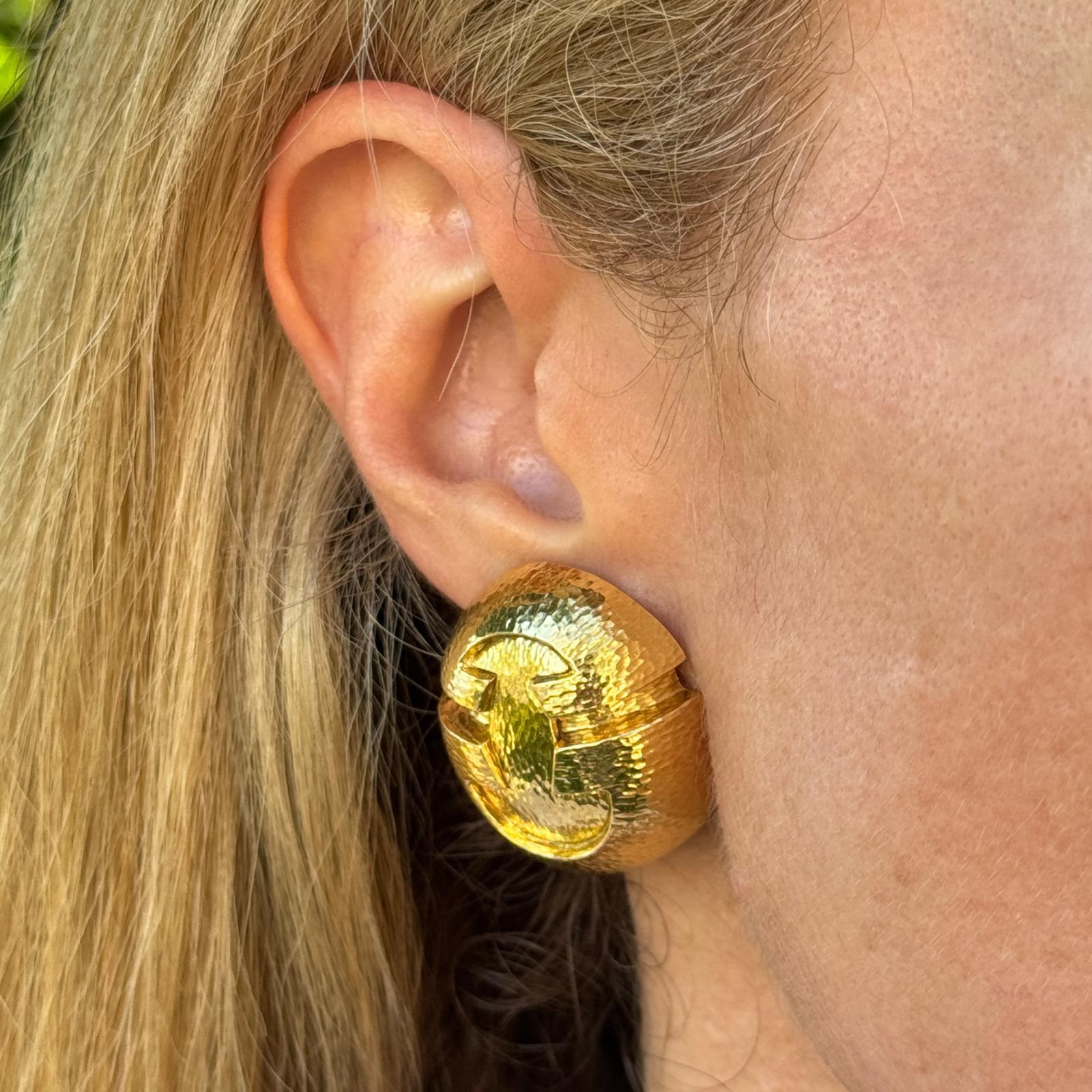 Élégantes et sculpturales, ces boucles d'oreilles en or jaune 18 carats de David Webb présentent une finition martelée distinctive qui reflète l'esthétique à la fois audacieuse et raffinée du créateur. Mesurant environ 1,0 x 1,25 pouces, ces boucles