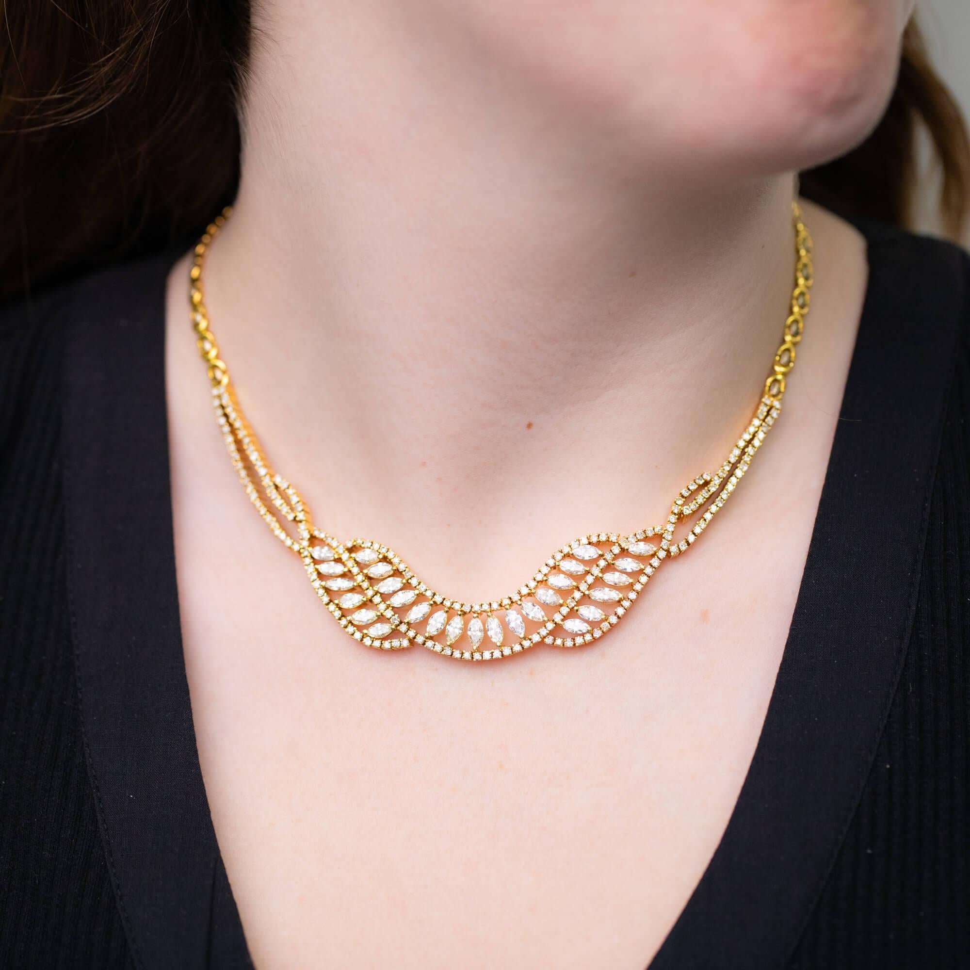 Questa collana della fine del XX secolo presenta una ghirlanda in oro giallo con diamanti taglio marquise e tondo brillante incastonati a griffe e una catena bicolore con chiusura a scatola e chiusura di sicurezza a forma di otto per completare il
