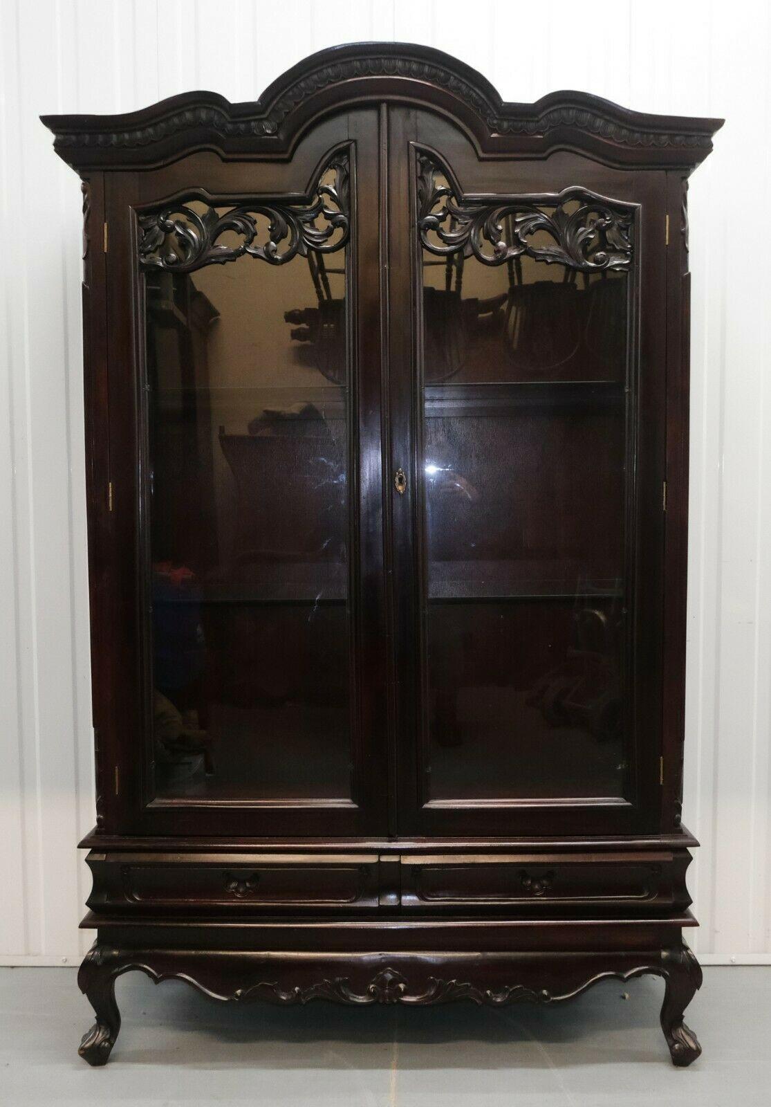 We are delighted to offer for sale this stylish Chinese hardwood glazed cabinet standing on cabriole legs.

The cabinet is charming and decorative, with a pair of drawers, glazed side panels and two glass shelves for display and storage. 

The