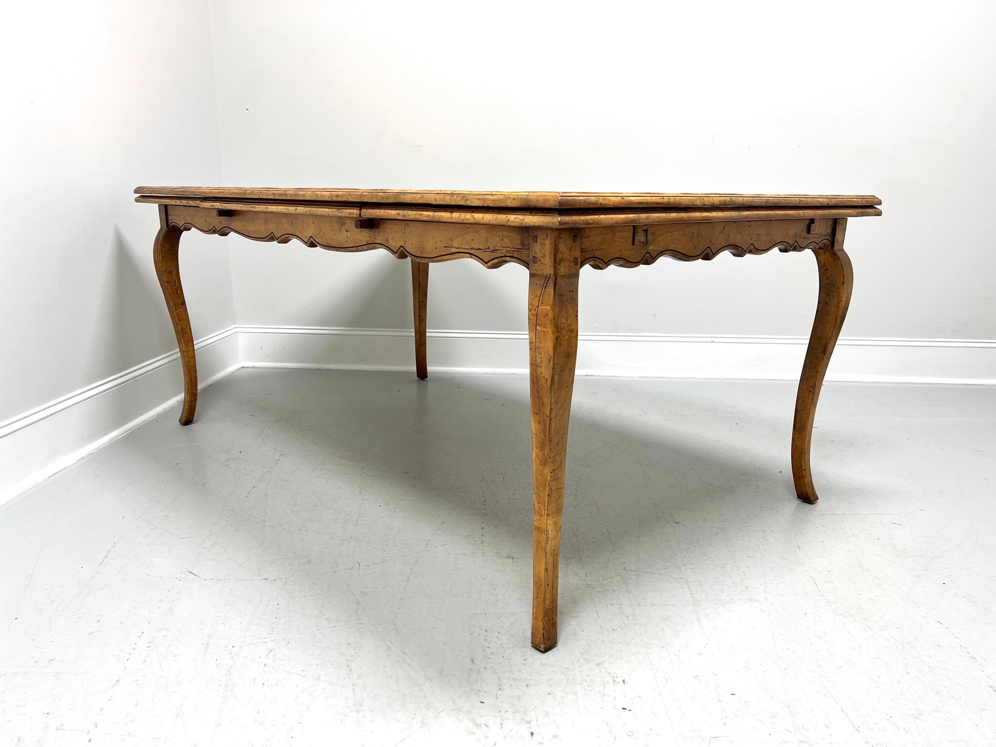 A drawtop dining table in the French Country style, unbranded. Nutwood with a distressed finish, banded parquetry design to top, two self-storing draw leaves, carved apron, and cabriole legs. Leaves pull out from either end of the table and work on