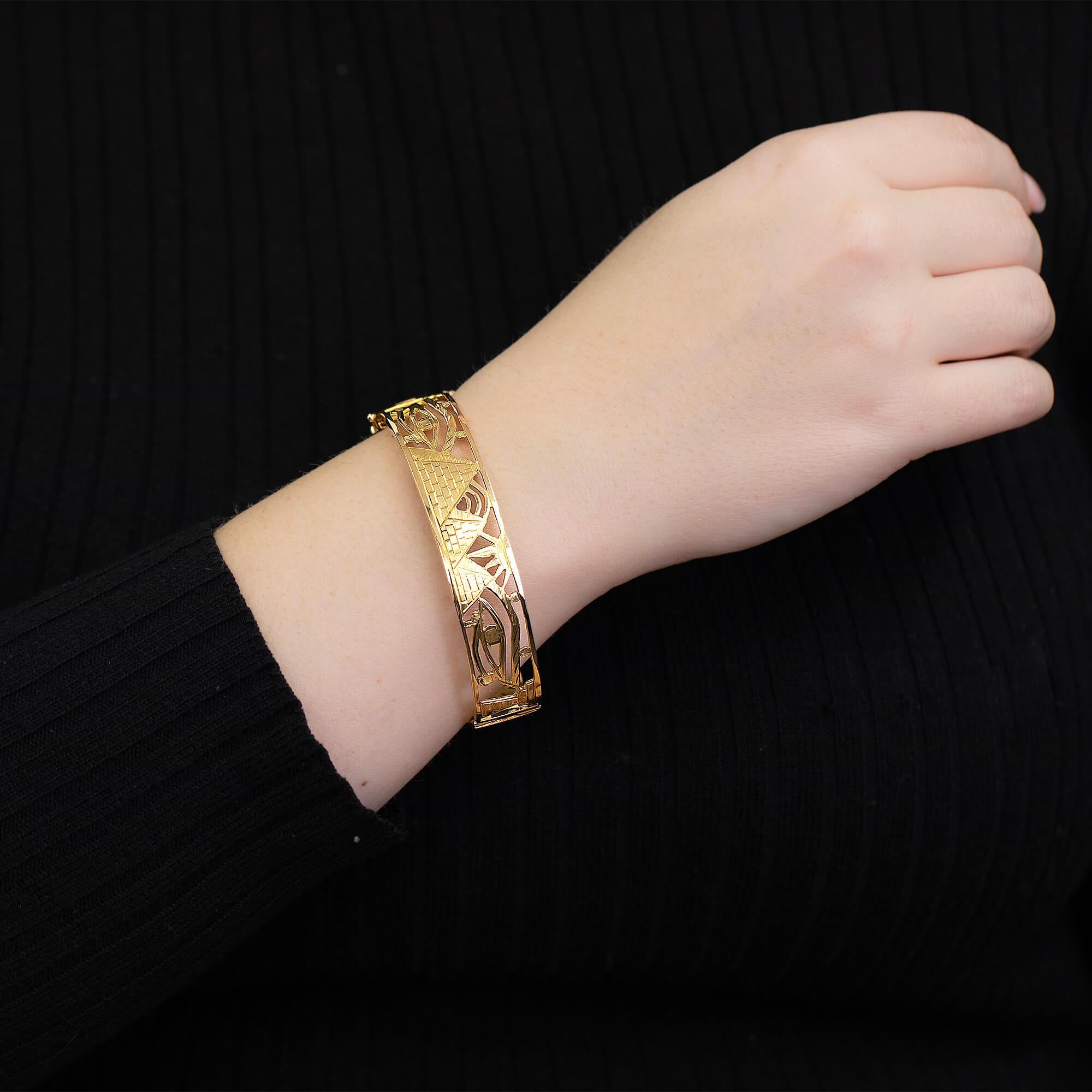 Bracelet à charnière égyptien de la fin du 20e siècle. Réalisé en or jaune 18 carats avec des hiéroglyphes égyptiens. Fermeture avec un fermoir en forme de boîte et deux fermoirs de sécurité en forme de huit. Estampillé du poinçon égyptien de 18