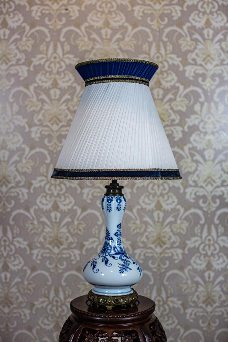 Late 20th-Century Electric Table Lamp with Ceramic Body and Brass Base

We present you this electric table lamp from the 2nd half of the 20th century.
The cone-shaped lamp shade is covered with frilly fabric and finished with trimming.
Furthermore,