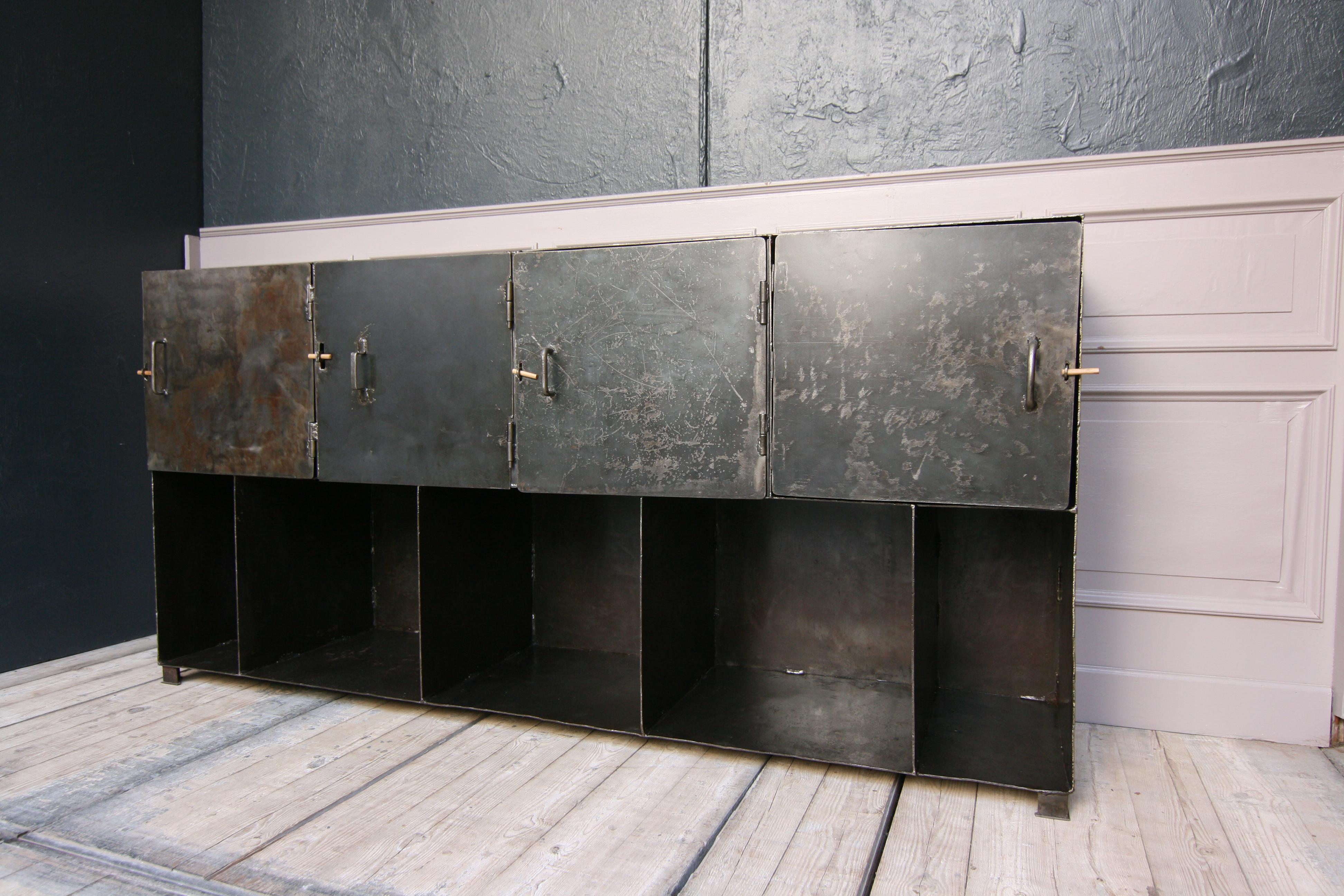 A late 20th century, very heavy solid shelf or sideboard made of metal.
4 doors above, open compartments below.