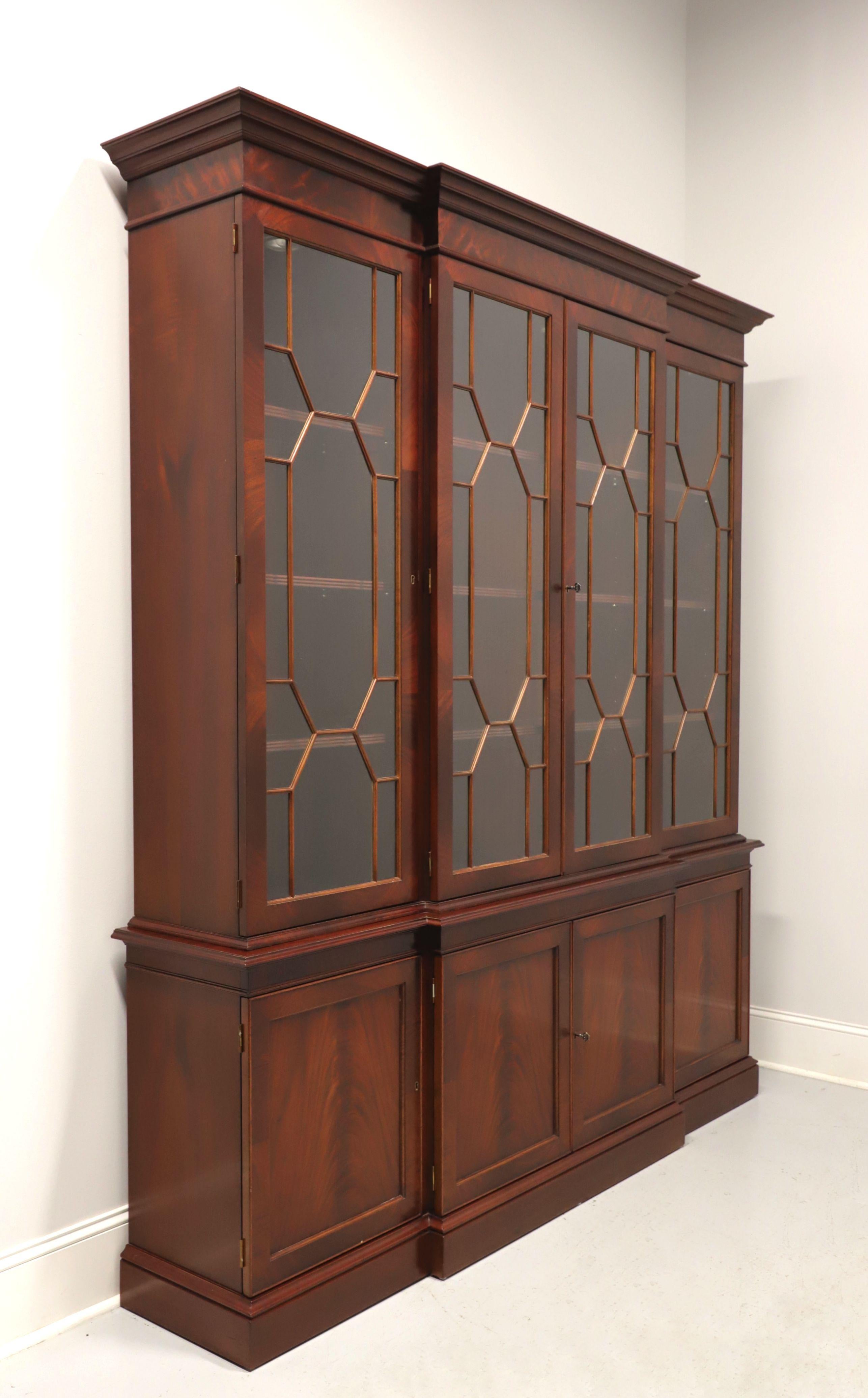A Chippendale style breakfront china cabinet, unbranded, similar quality to Century or Hickory Chair. Flame mahogany with brass hardware and crown molding at top. Upper lighted cabinet has three separate areas with dual center and flanking side