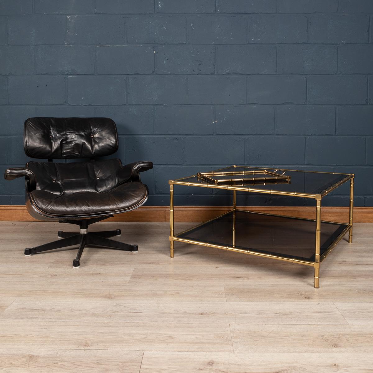 A very large coffee table by Maison Jansen, made in France around the 1970s. The faux bamboo frame made out of brass supporting dark smoked glass on two levels. A truly elegant solution for any interior looking to enrich the room with a little