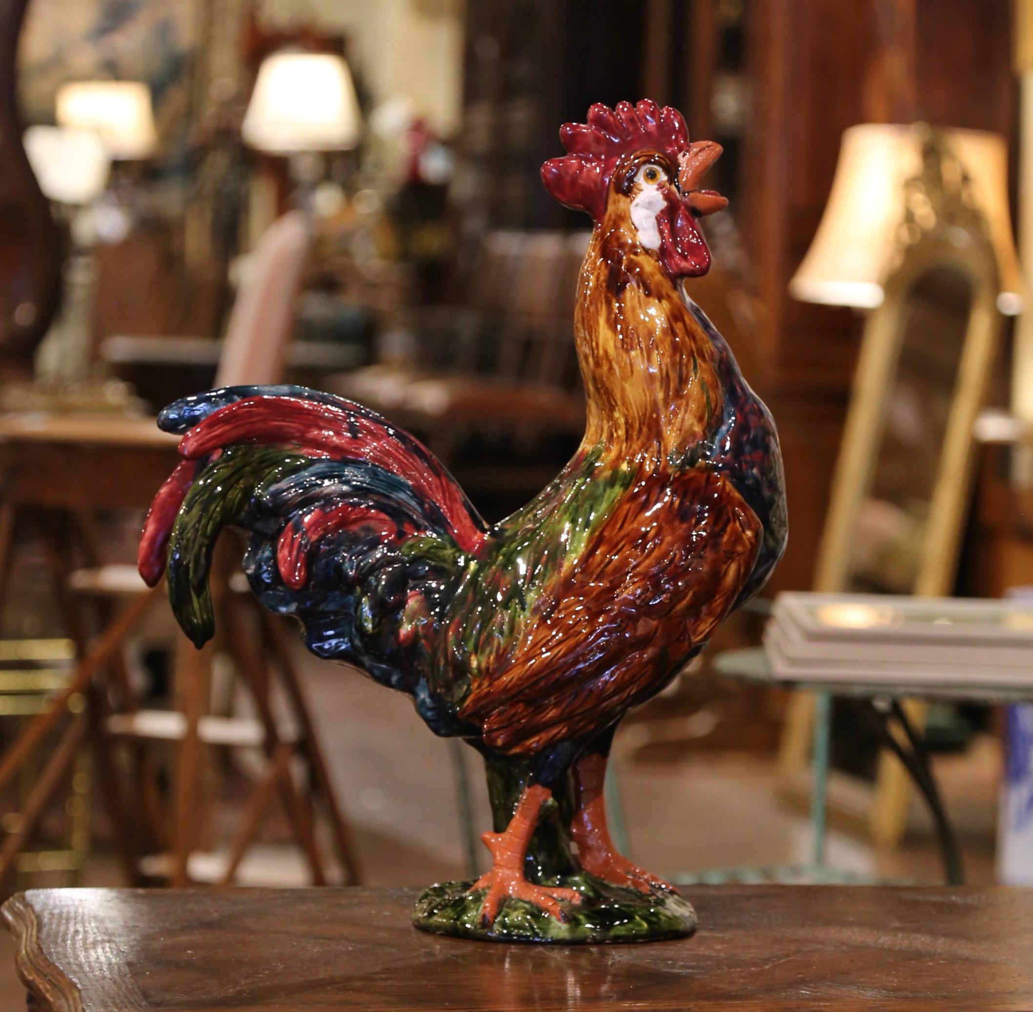 This large colorful Majolica rooster was crafted in Normandy, circa 1980. Hand painted in the blue, green and brown palette, the proud symbol of France stands tall on a green base. The ceramic sculpture is in excellent condition with rich hand