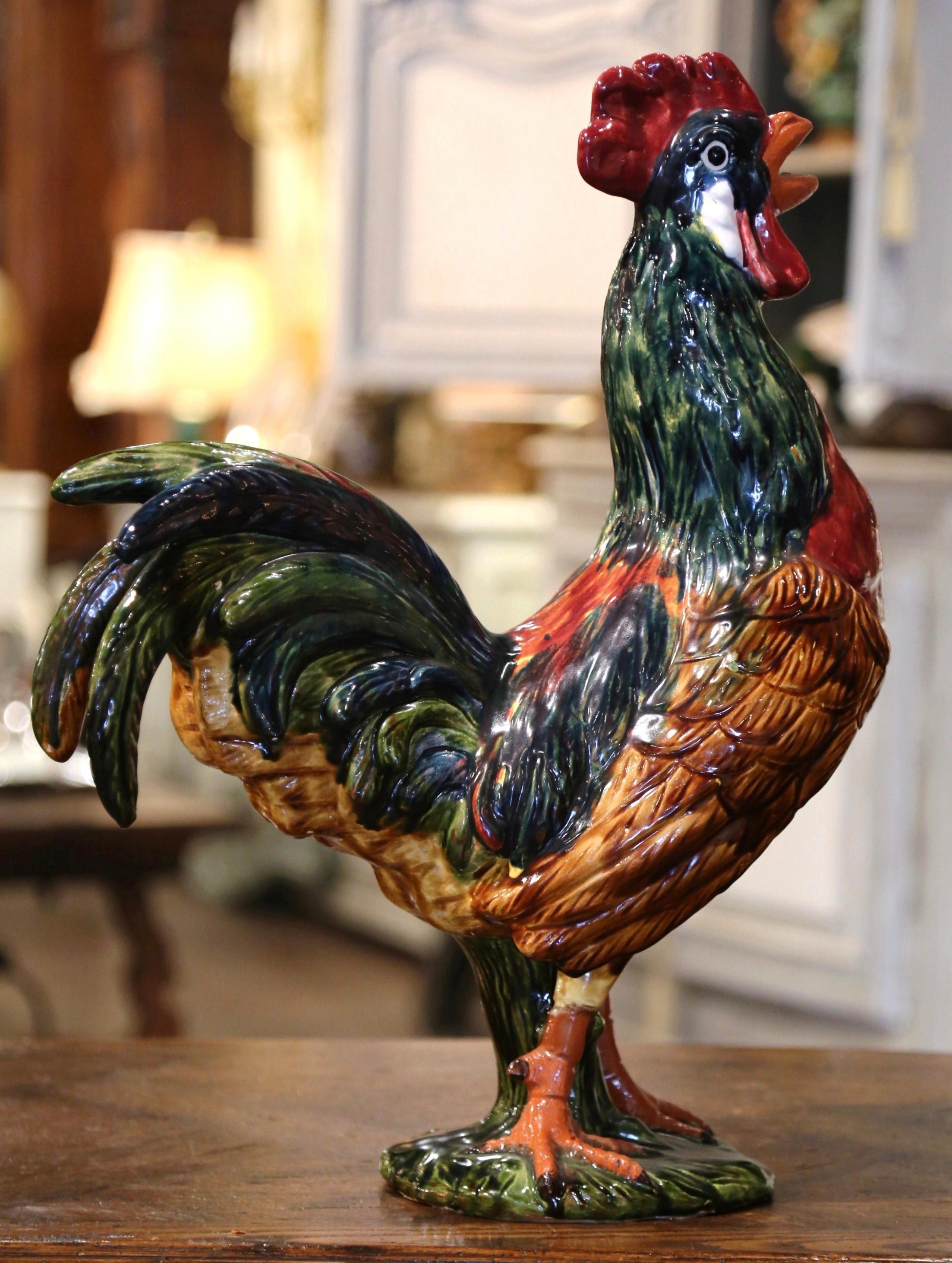 This large colorful Majolica rooster was crafted in Normandy, circa 1980. Hand painted in the blue, green and brown palette, the proud symbol of France stands tall on a green base. The ceramic sculpture is in excellent condition with rich