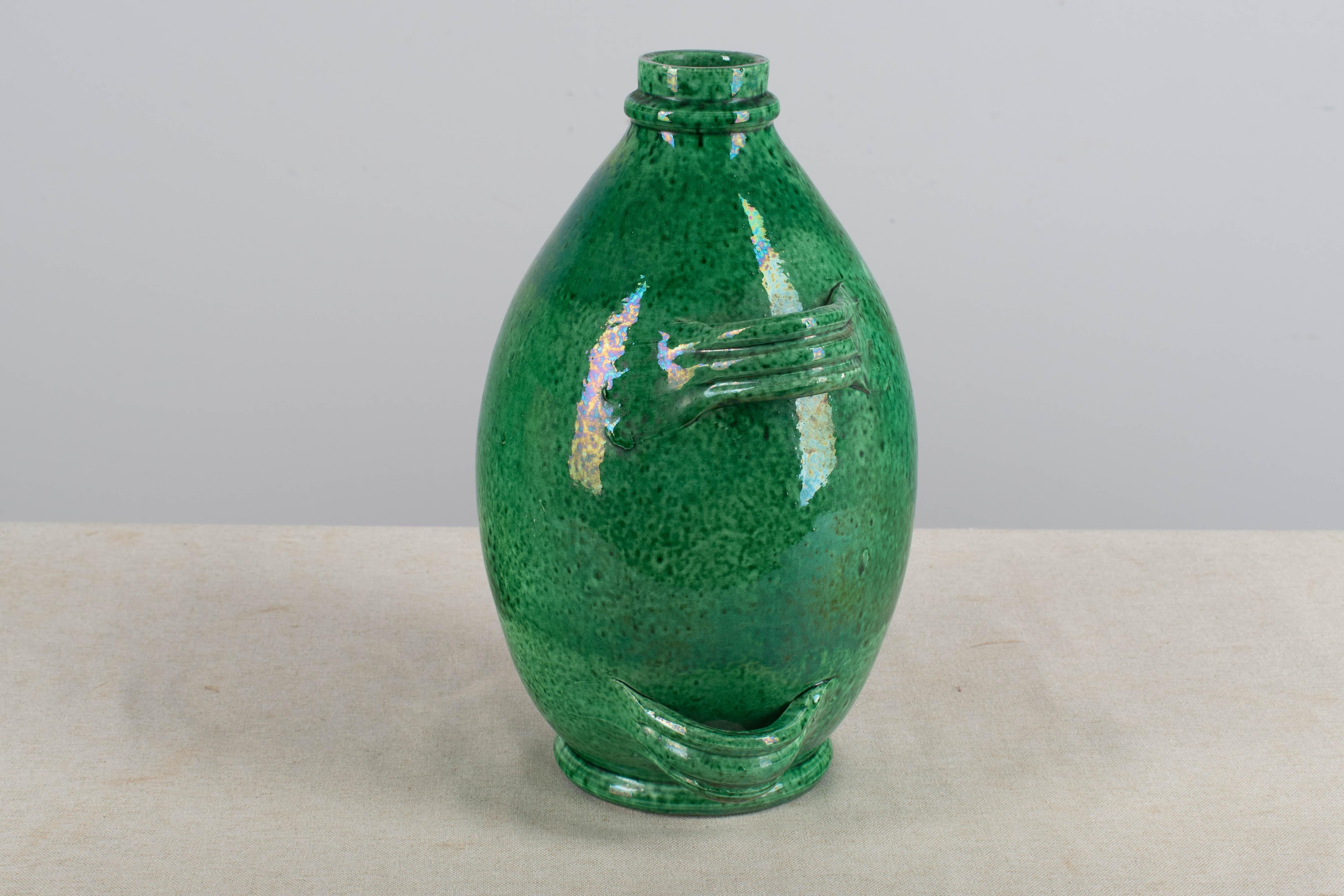 A late 20th Century French Pottery from Vallauris called a Conscience was used to store olive oil. Green glazed in good condition with micro chip at the rim. Circa 1960. Dimensions are 12